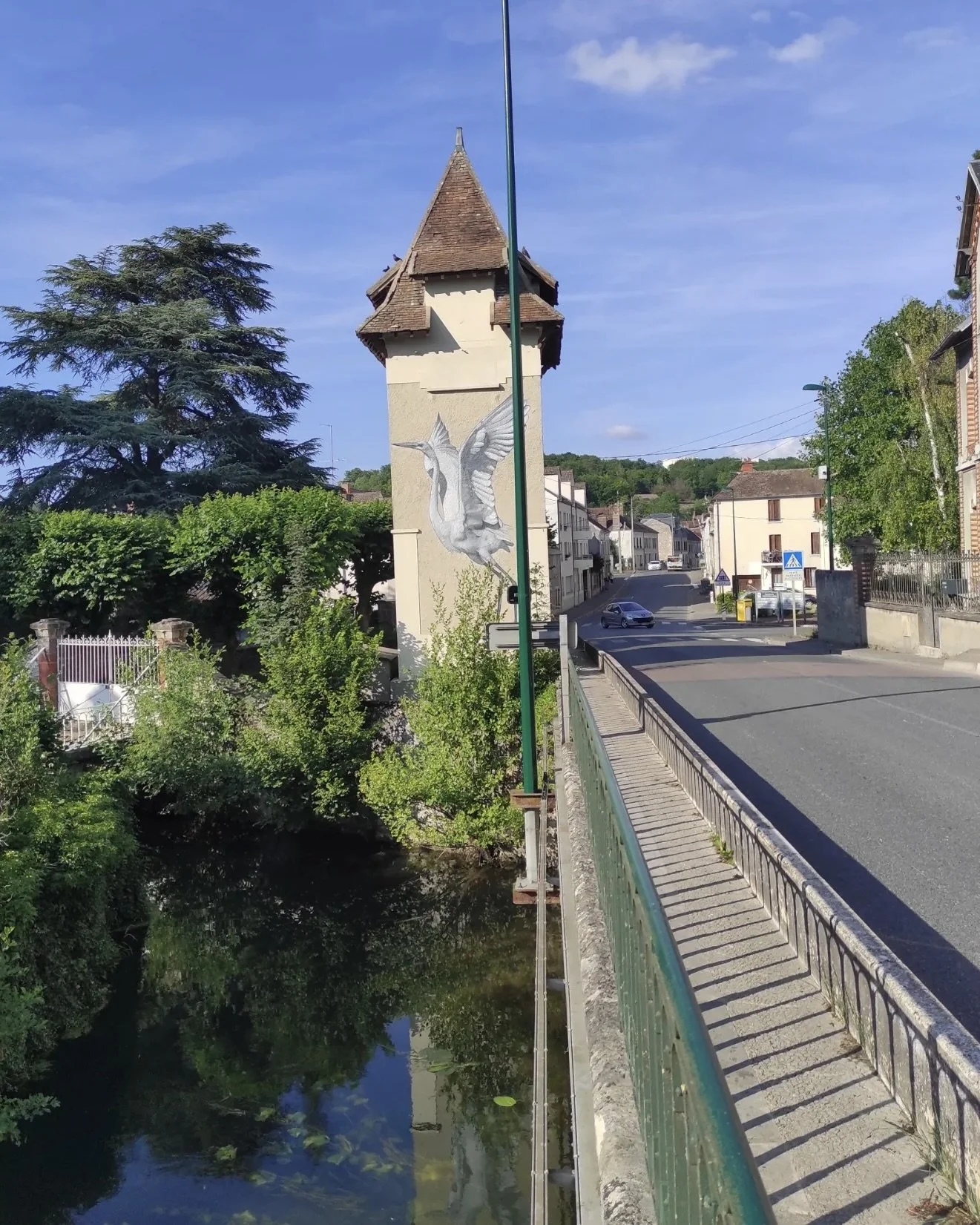Vue du transformateur en bordure du Loing avec une fresque d’aigrette blanche visible dans son environnement urbain et paysager.
