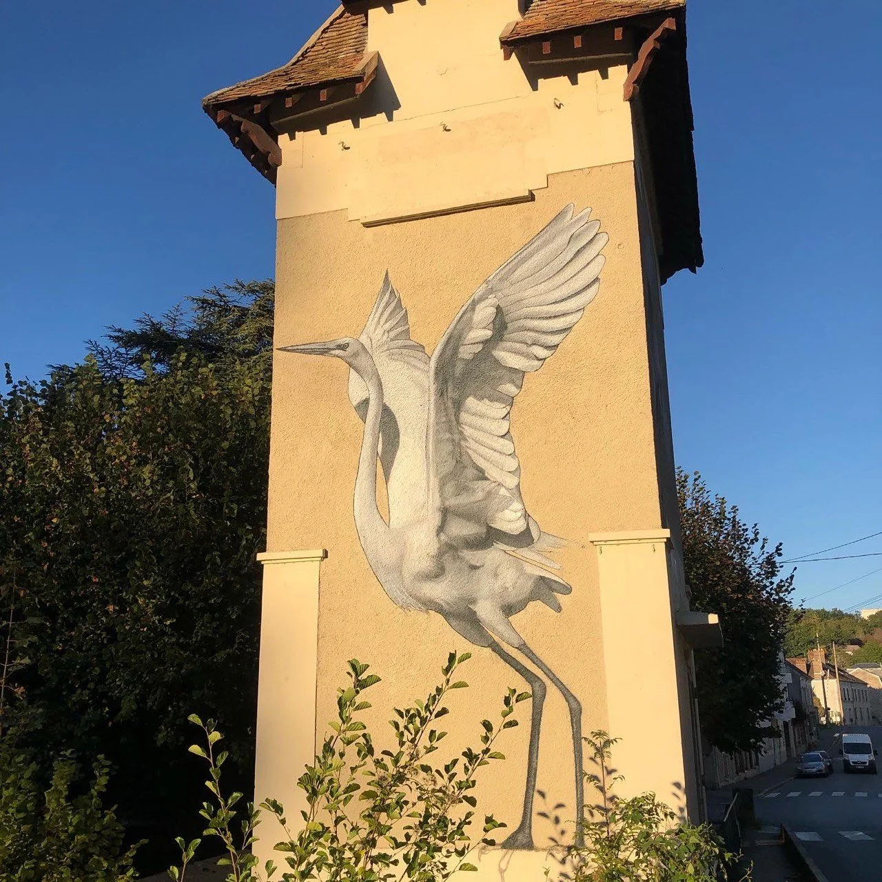 Fresque murale représentant une aigrette blanche peinte en grand format sur la façade d’un transformateur Enedis à Souppes-sur-Loing.