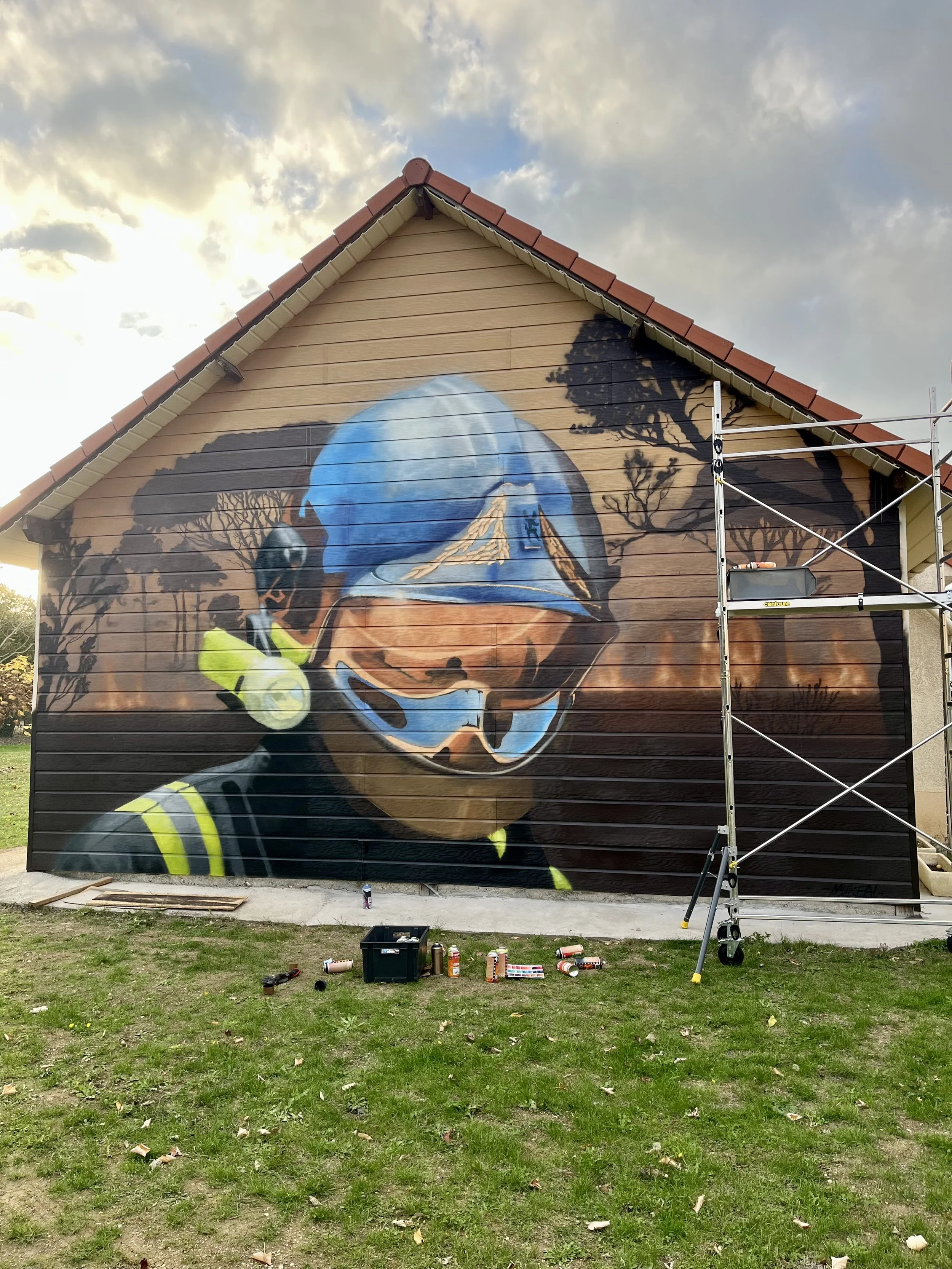 Détail d'une fresque de pompiers réalisée à la bombe sur une façade de maison à Auxy.