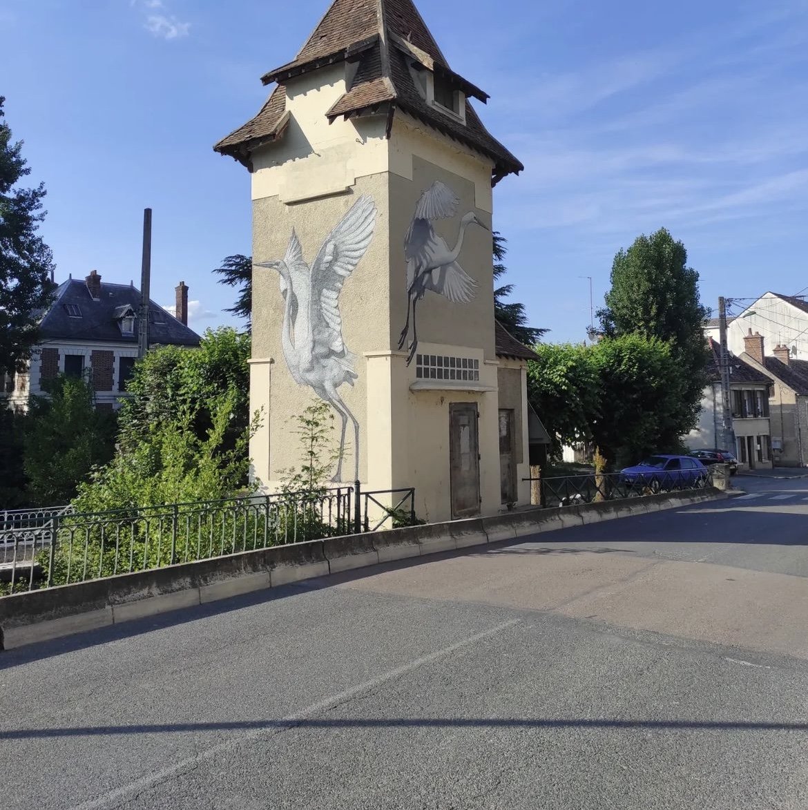 Vue d’ensemble d’un transformateur situé près du Loing avec une fresque d’aigrette blanche intégrée à l’architecture du bâtiment.