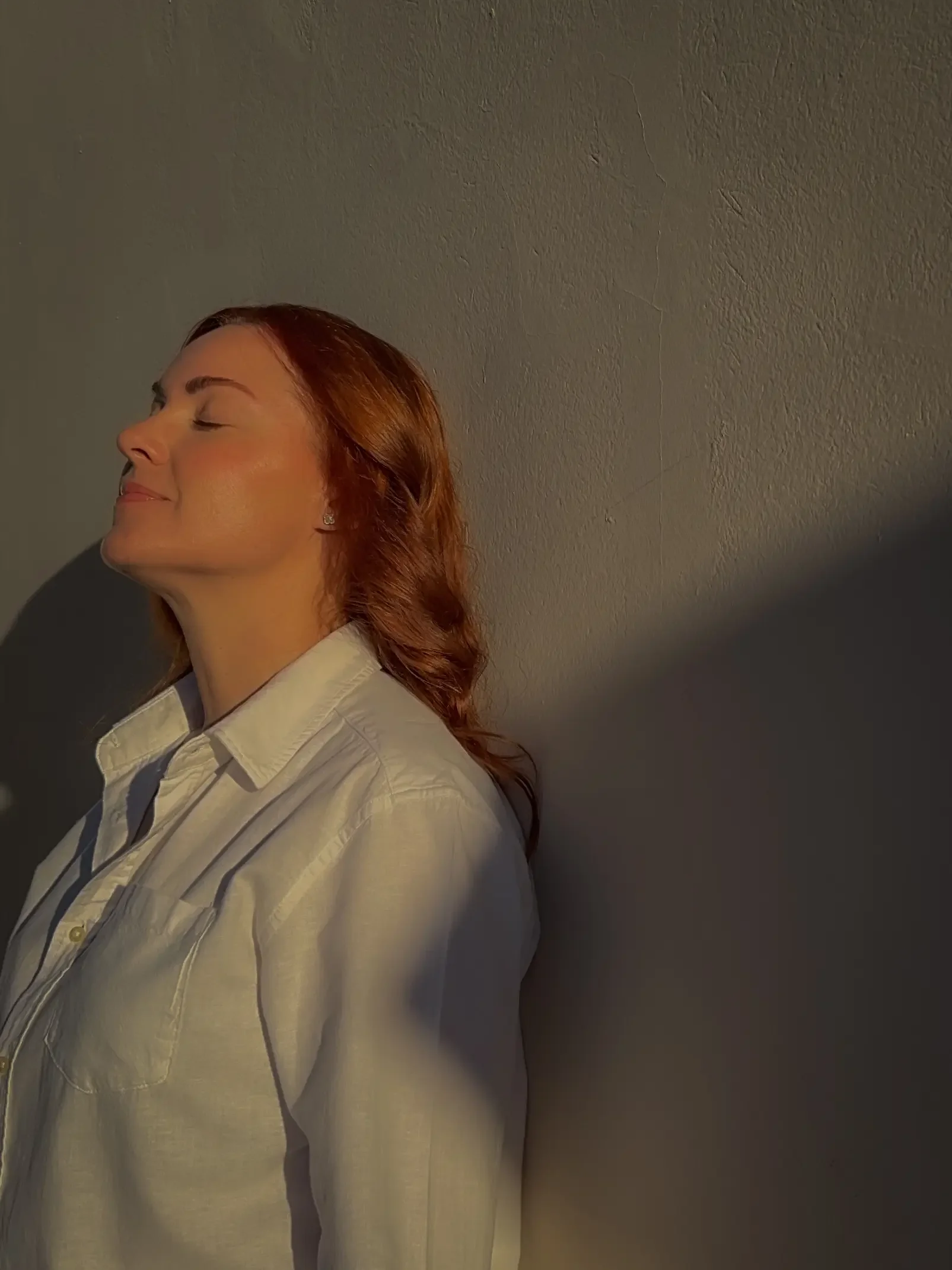 woman standing in sunlight eyes closed feeling grounded individual therapy for relationship issues New York