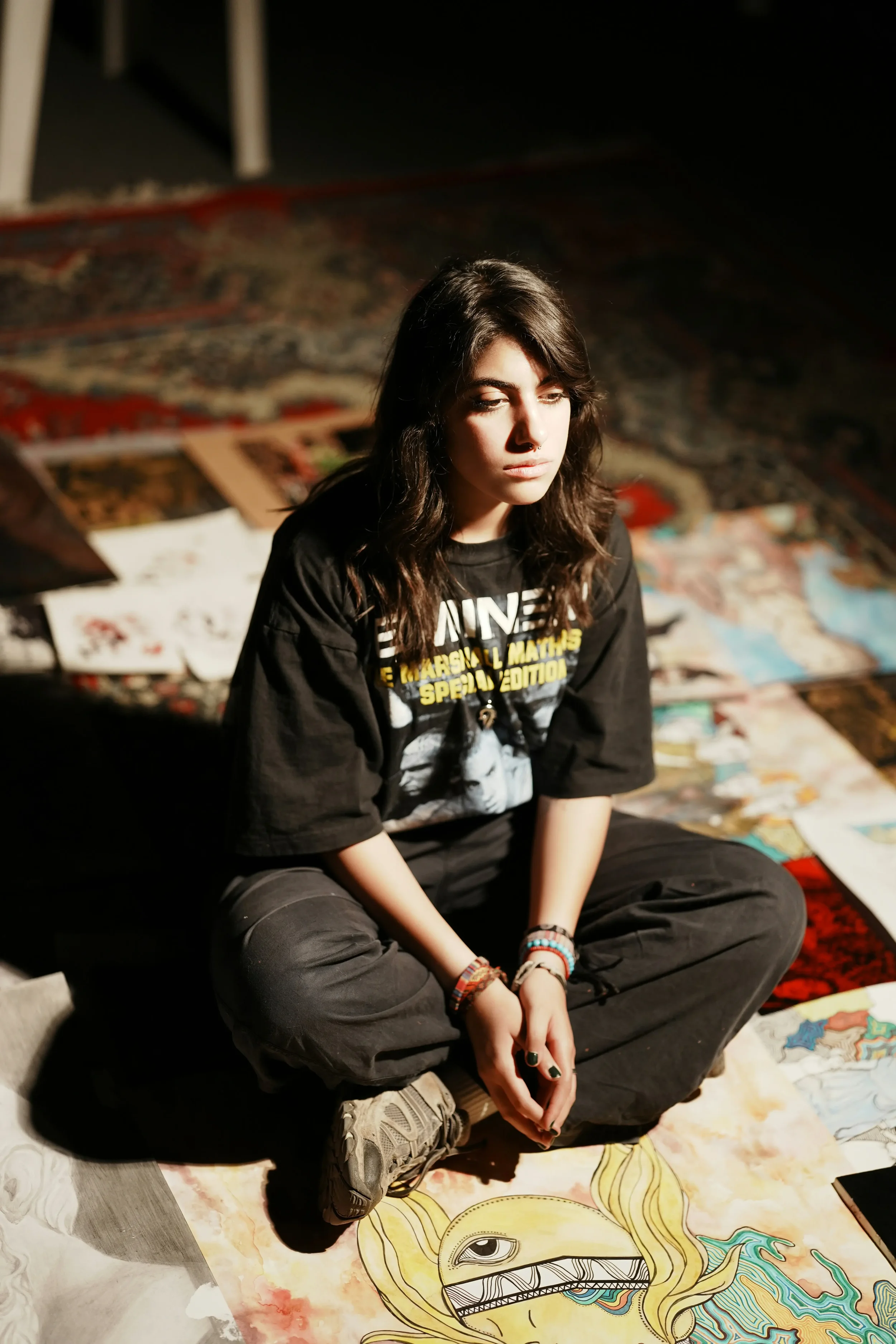 Artist sitting on the floor surrounded by artwork, reflecting creative block and impostor syndrome in therapy for artists in New York City