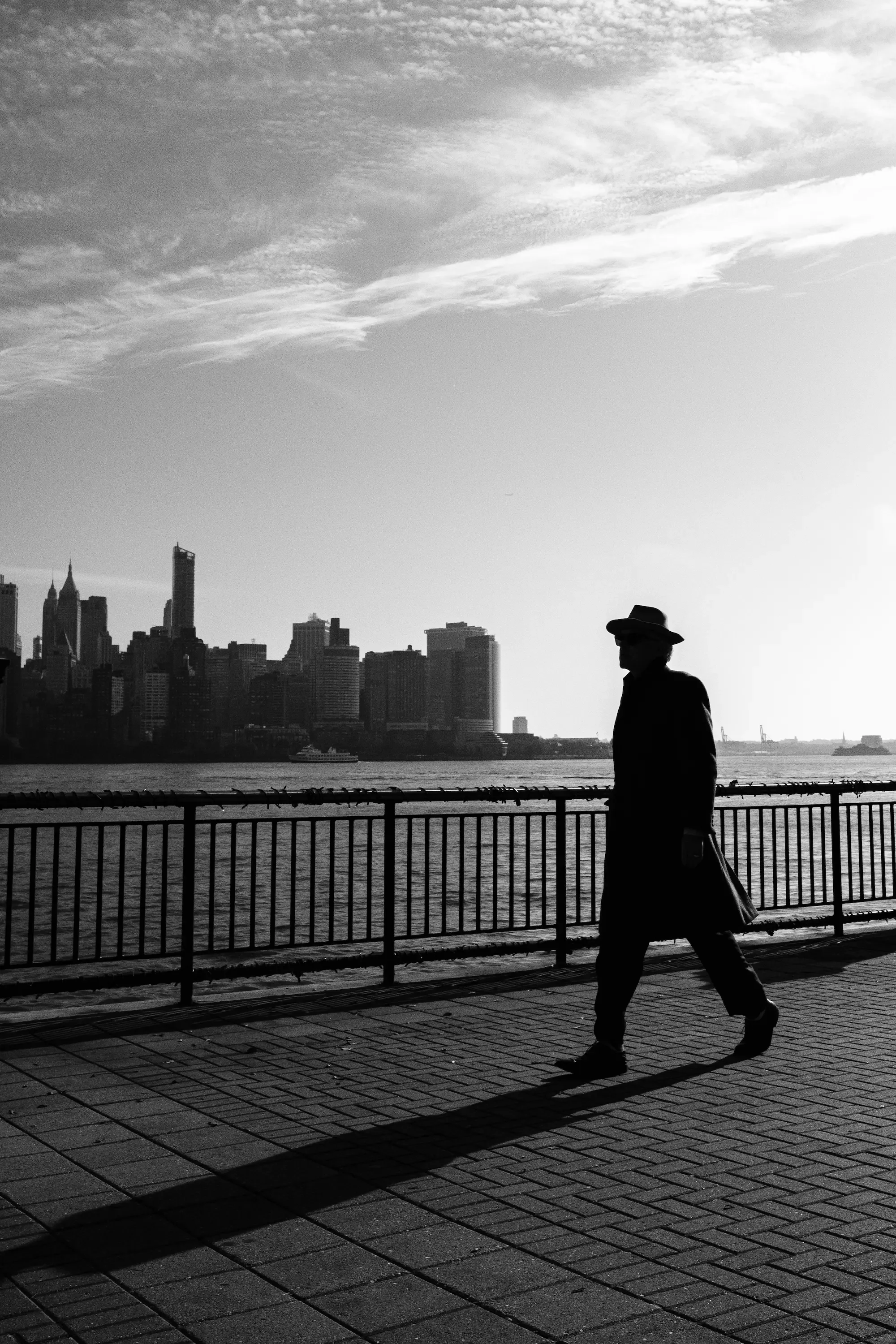 Person walking alone by the New York City skyline, reflecting the emotional uncertainty explored in therapy for artists in New York City