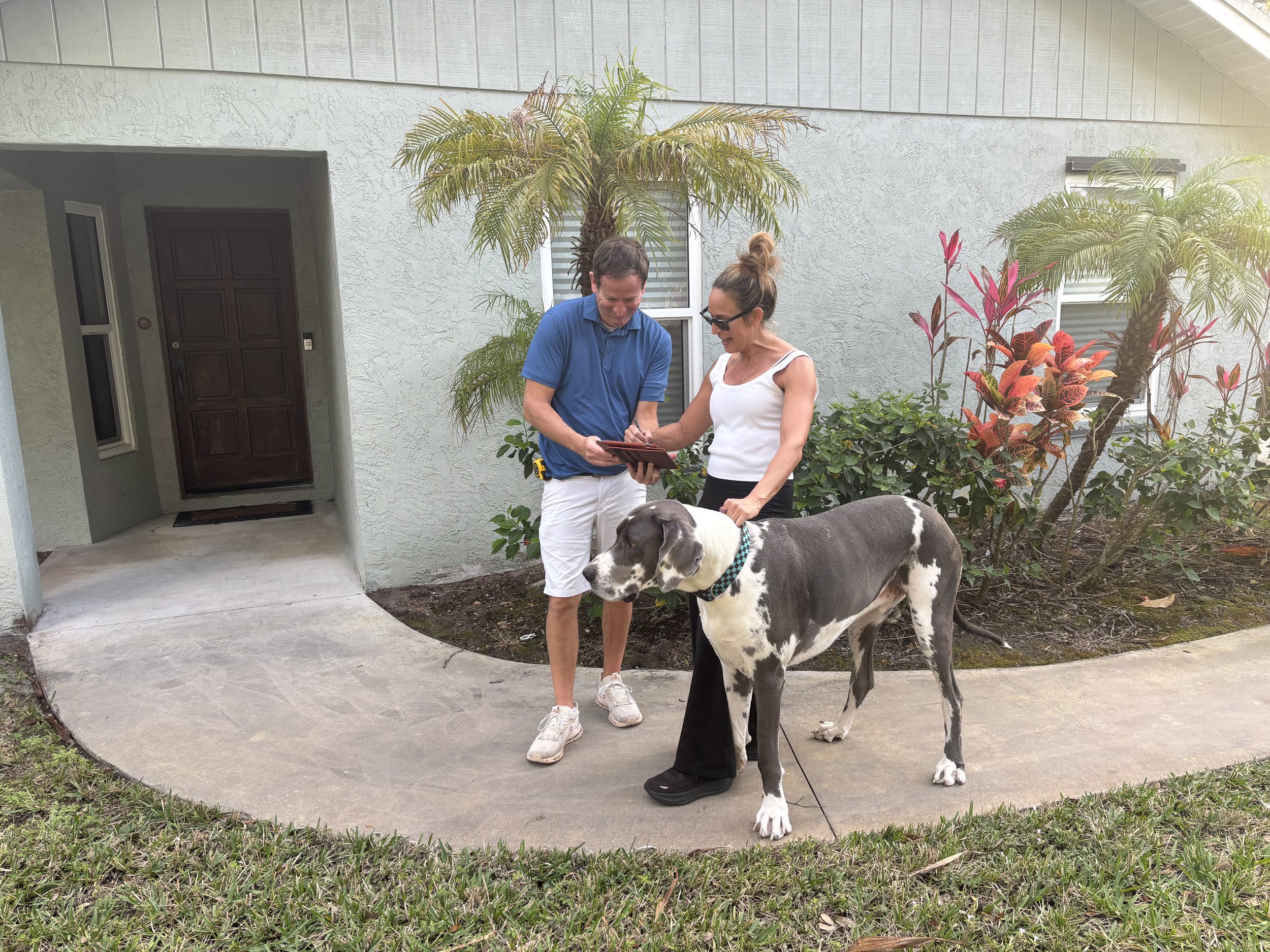 Treasure Coast homeowner reviewing inspection details with Reamer Homes owner and her dog