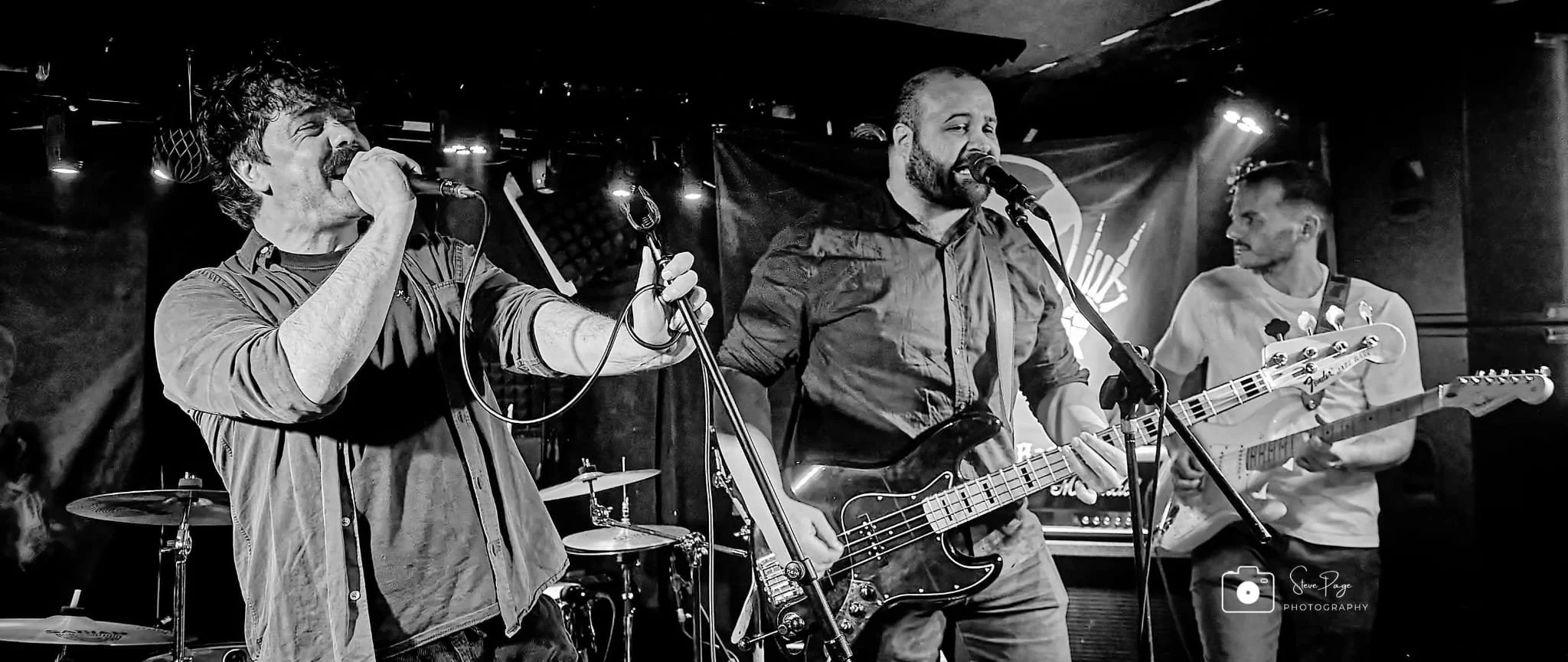 SOMB Scared of My Brother performing on stage:all under stage lights in a black and white photo.
