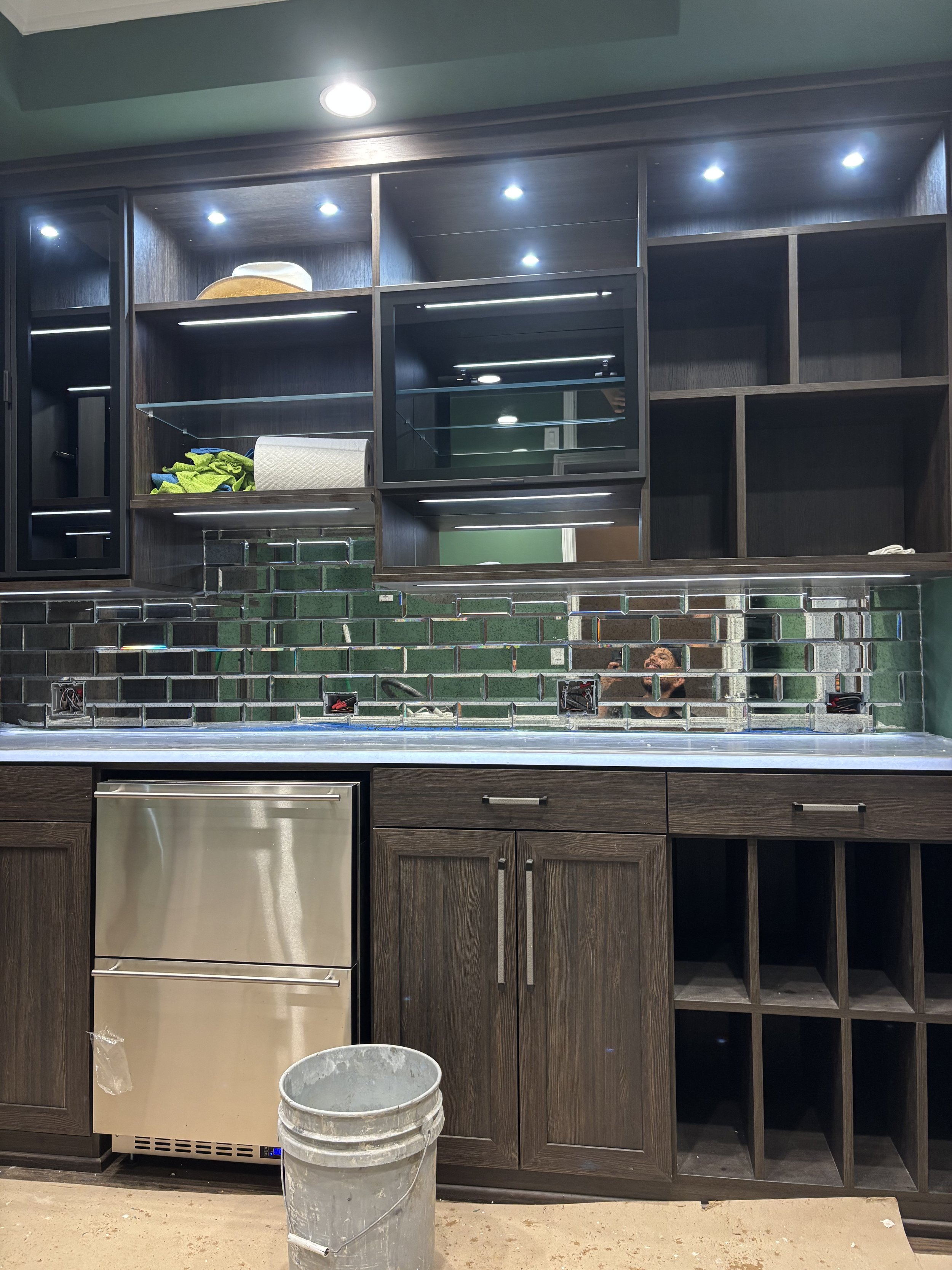 Custom glass tile backsplash featuring a reflective mosaic design that beautifully complements the dark wood cabinetry, adding depth, contrast, and a modern touch to the space.