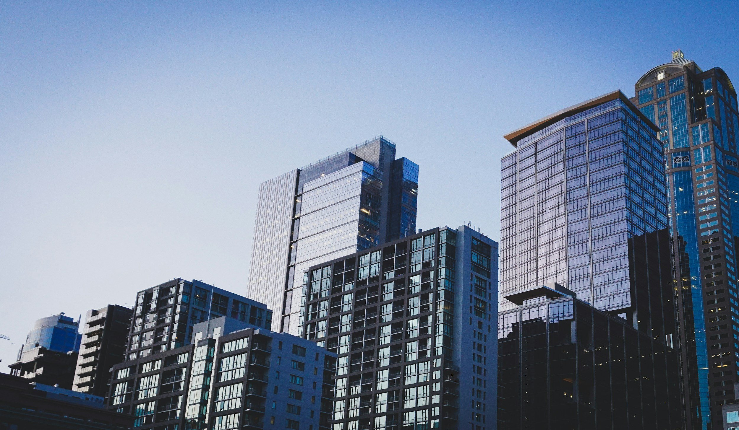 Skyline of modern glass skyscrapers and high-rise office buildings in an urban cityscape during daytime.