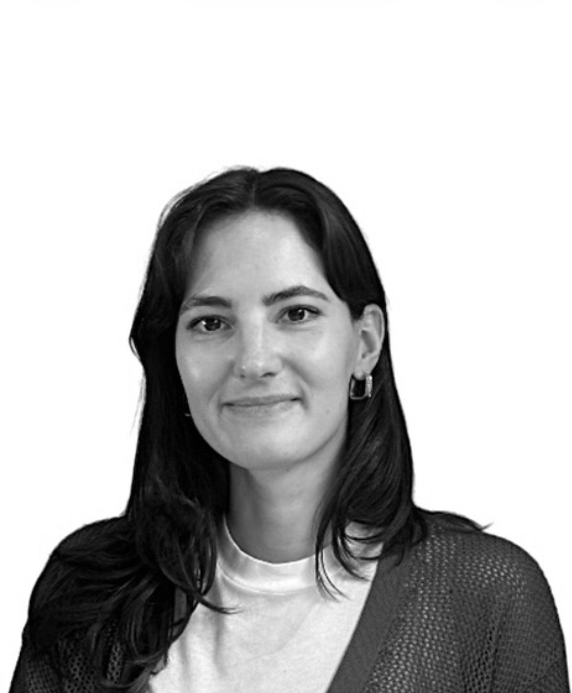 Black and white portrait of a woman with shoulder-length dark hair, wearing hoop earrings, a white shirt, and a dark textured jacket, smiling softly.