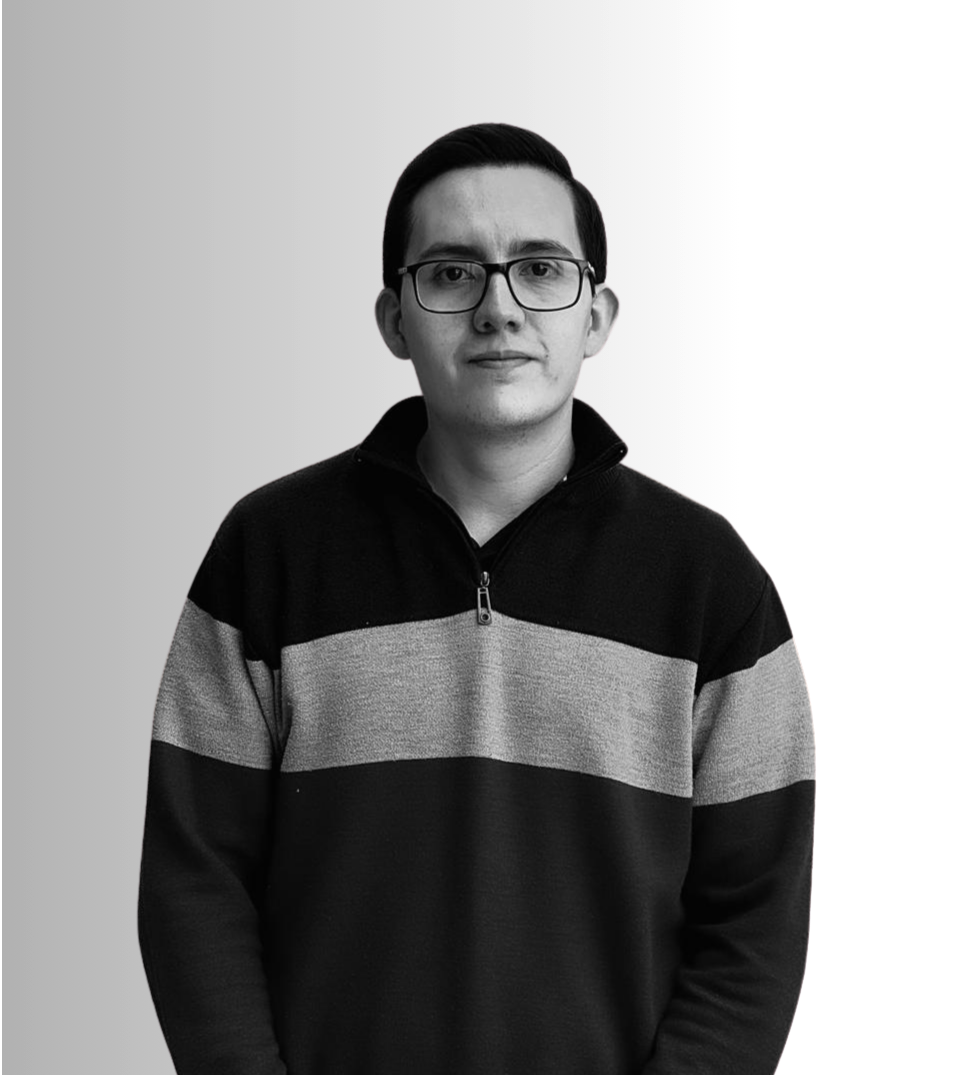 Retrato en blanco y negro de un hombre joven con gafas, cabello oscuro y liso, usando un suéter con franjas horizontales en gris y negro, frente a un fondo gris claro.