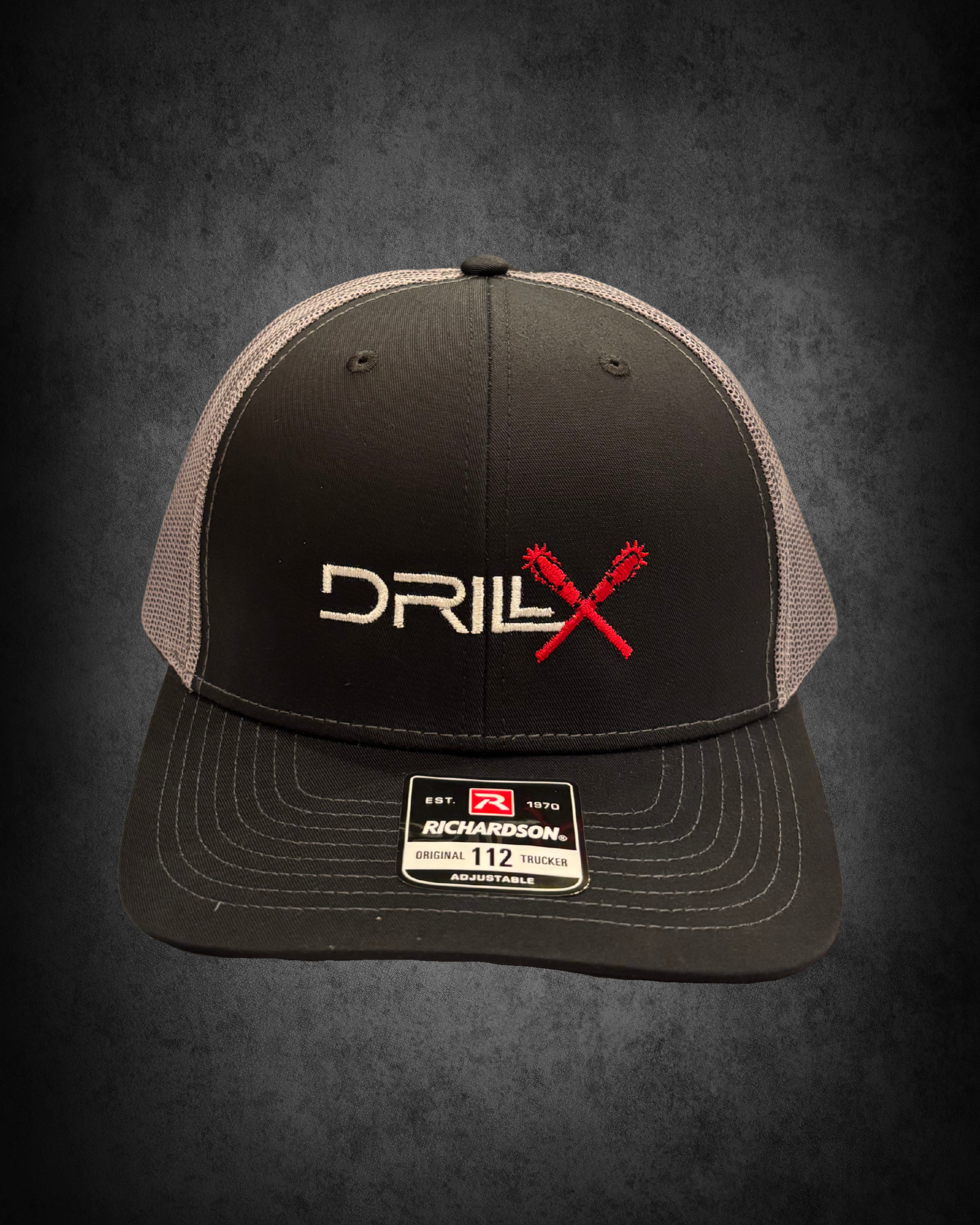 Black and gray Richardson trucker cap with red crossed wrenches and white text, displayed on a black surface with a price tag and size label.
