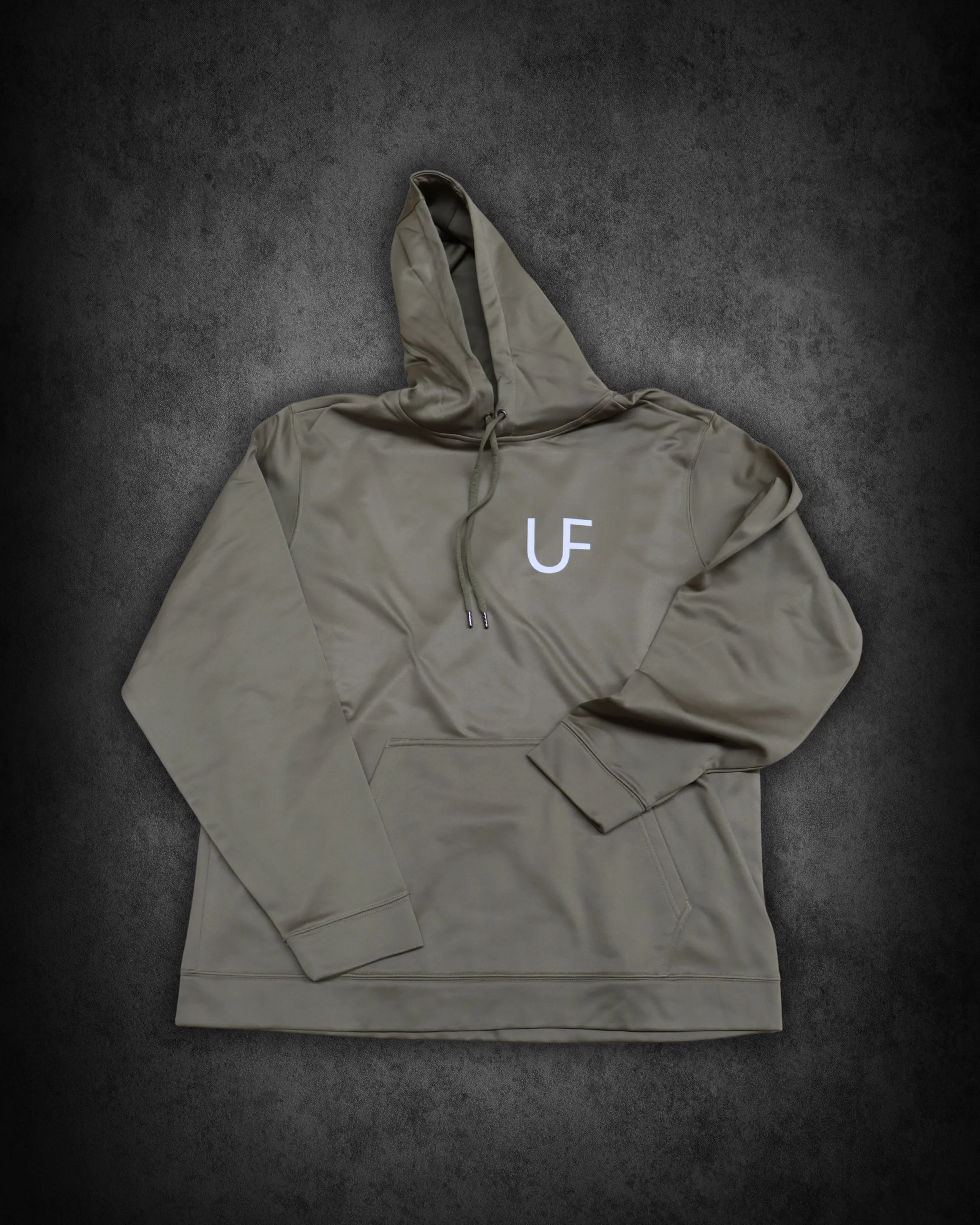 Beige hoodie with the letters 'LE U' printed on the front, lying on a dark grey surface.
