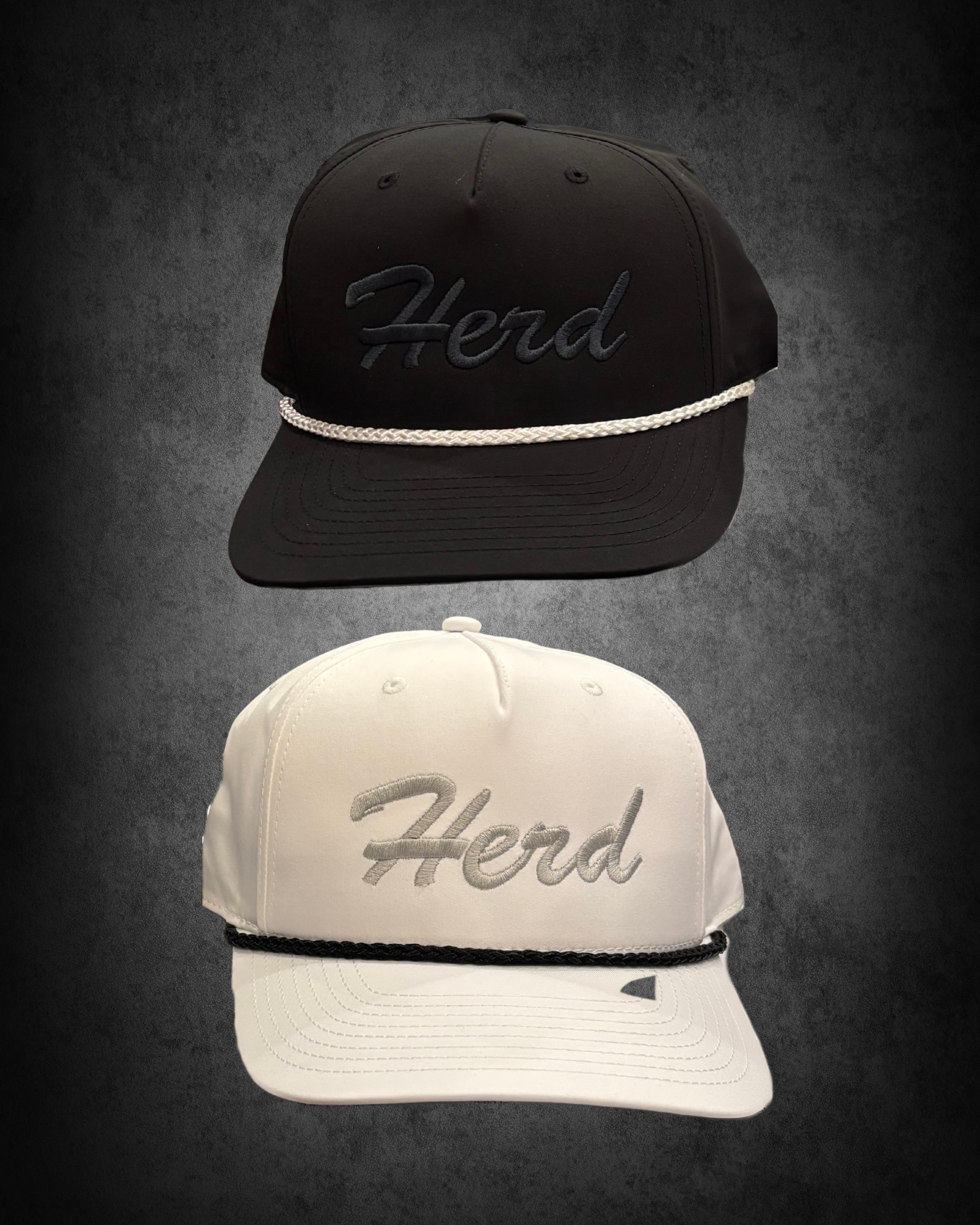 A black baseball cap with the word 'Herd' embroidered on the front, and a white braided rope detail along the bill, displayed against a dark background.
