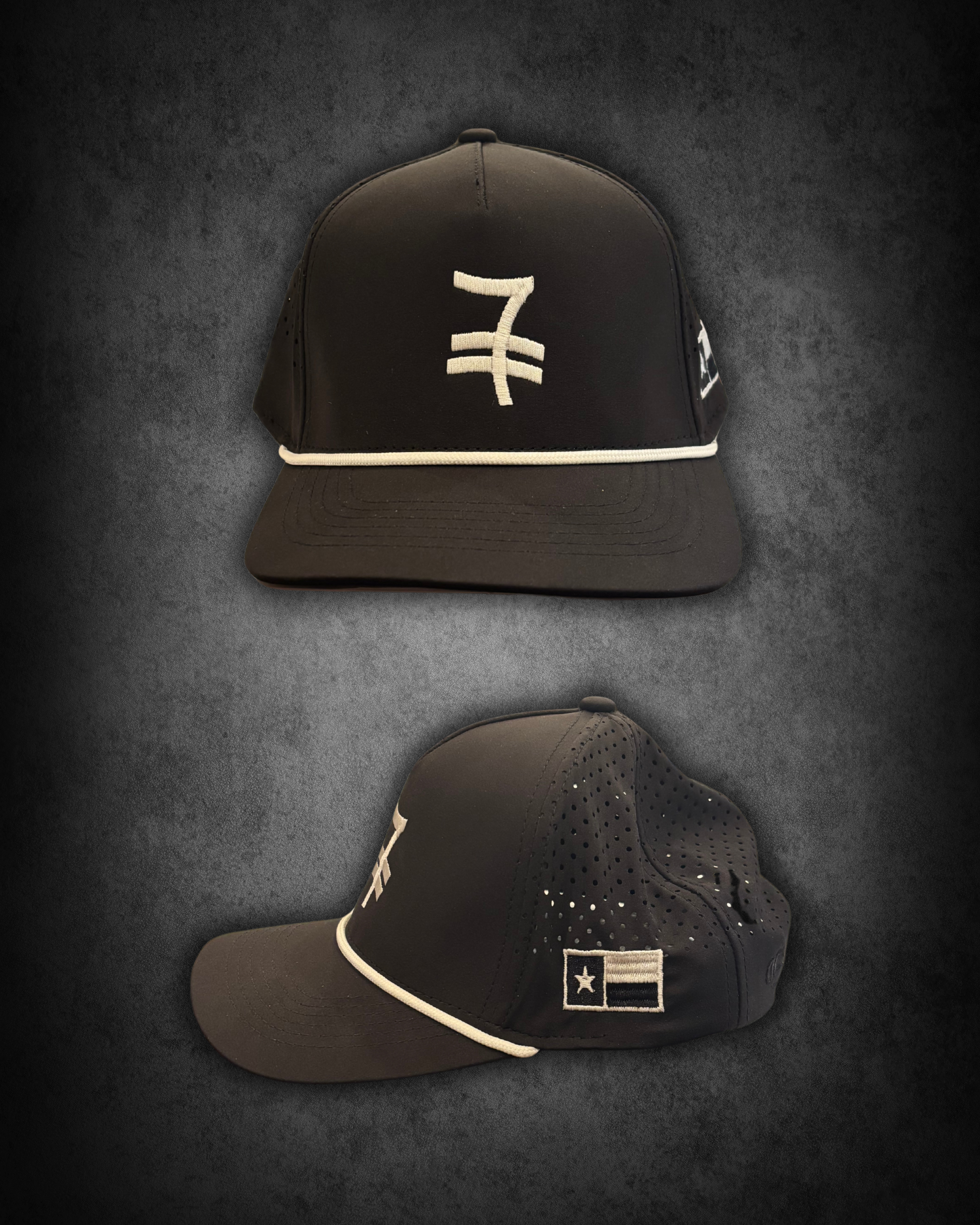Black baseball cap with a white embroidered logo and logo patch on the side, and white piping on the brim, placed on a textured black surface.