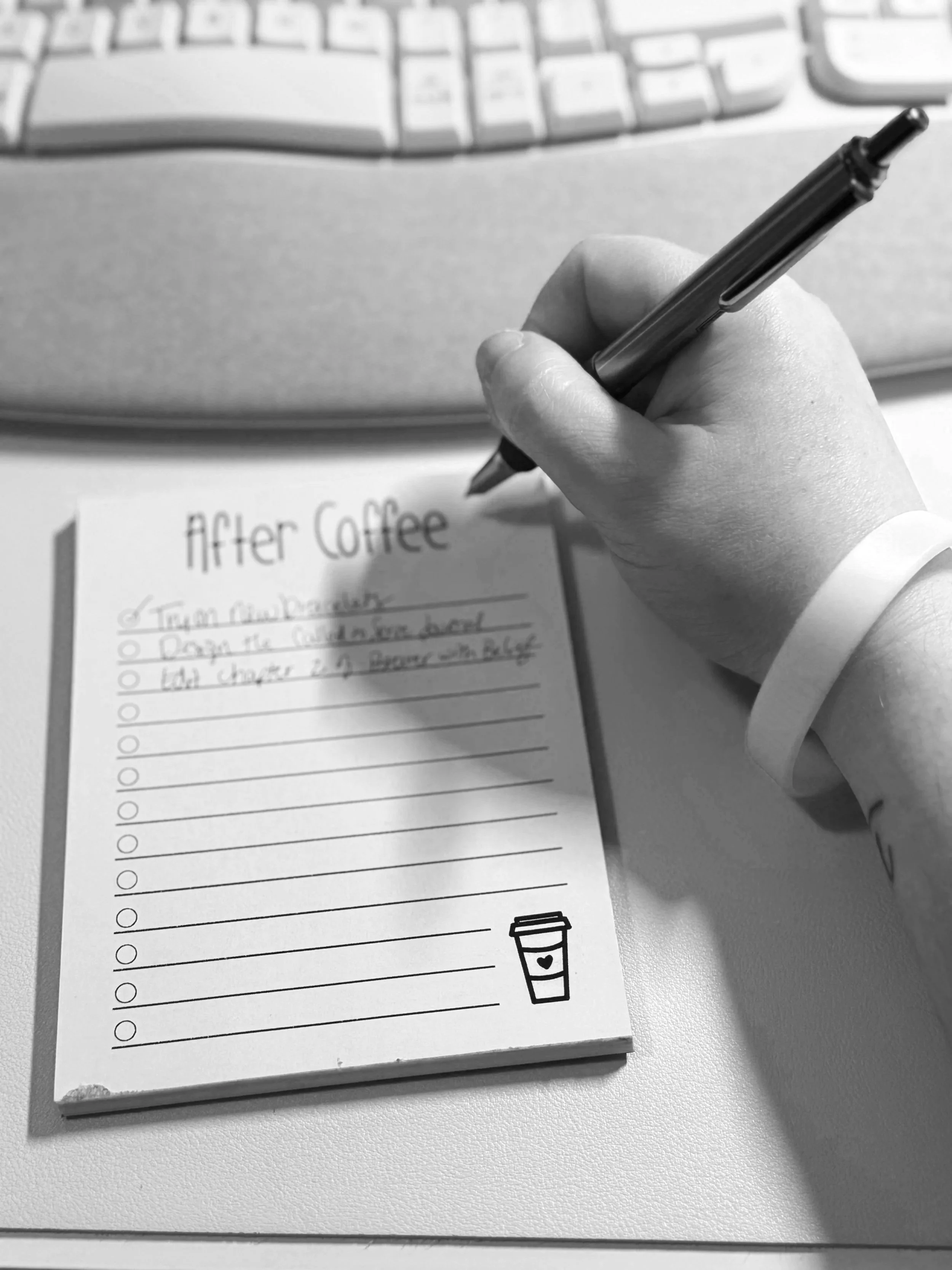 notepad that says after coffee and has a list written on it with a hand holding a pen