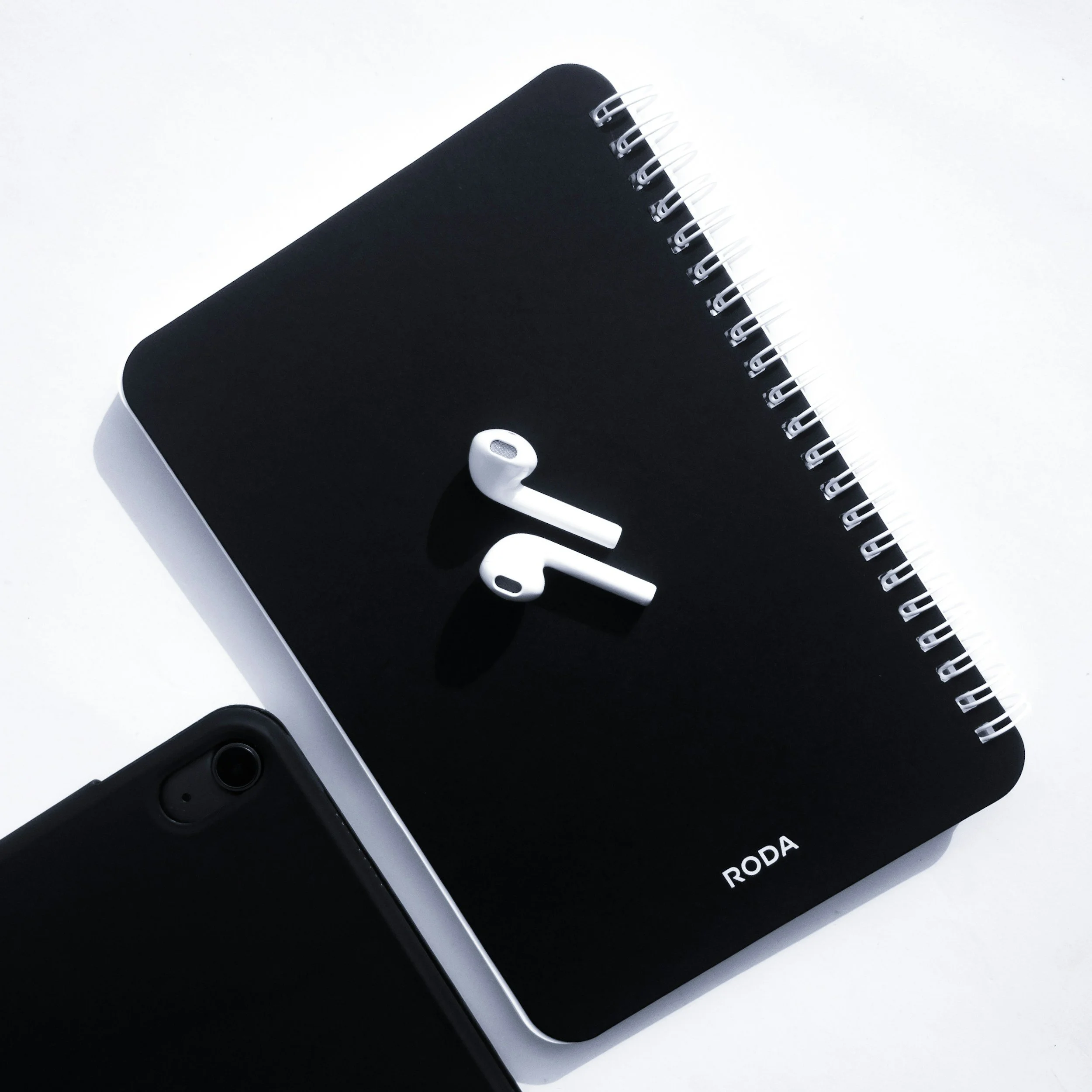 black notebook with airpods on top