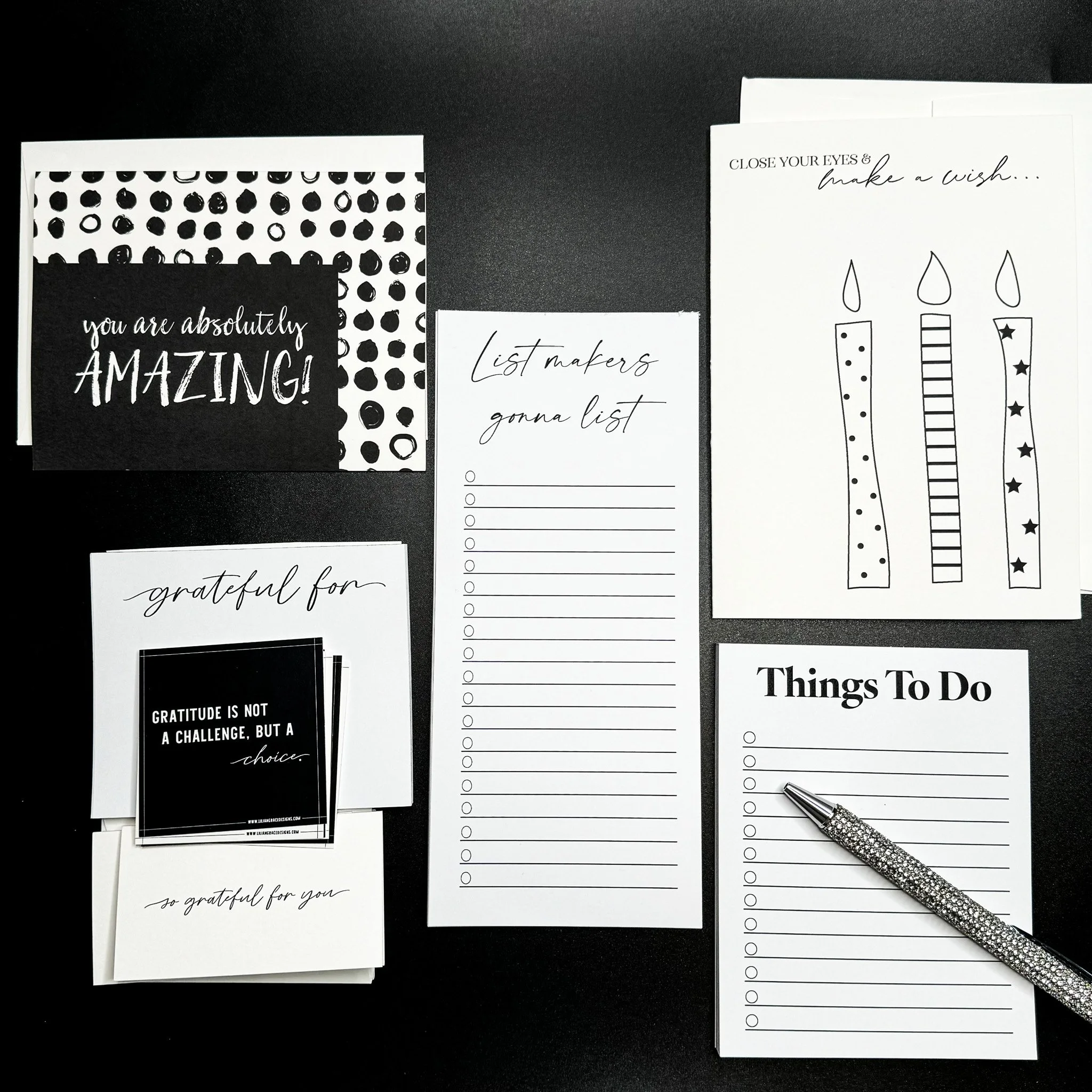 Greeting cards and notepads arranged with a pen on top