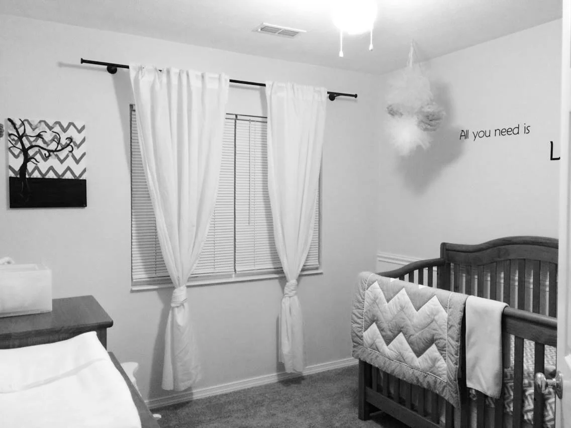 black and white image of a nursery with crib