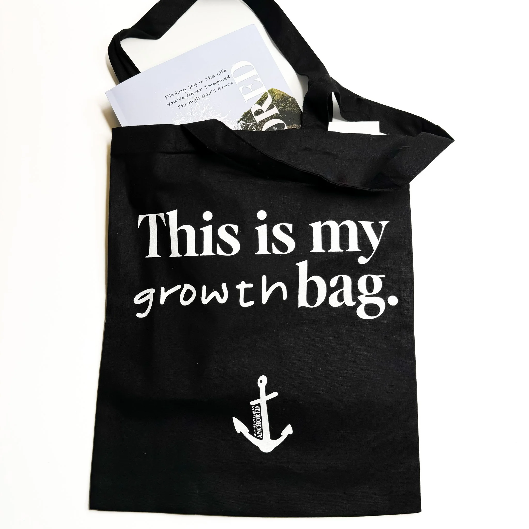 tote bag that says this is my growth bag with an anchor on it and the authentically anchored book inside