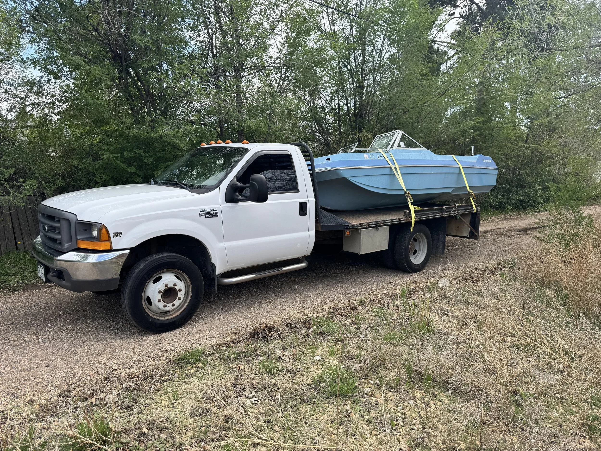 Unwanted boat hauled away on flatbed with 3 Peaks' hassle-free boat removal service in Northern Colorado.