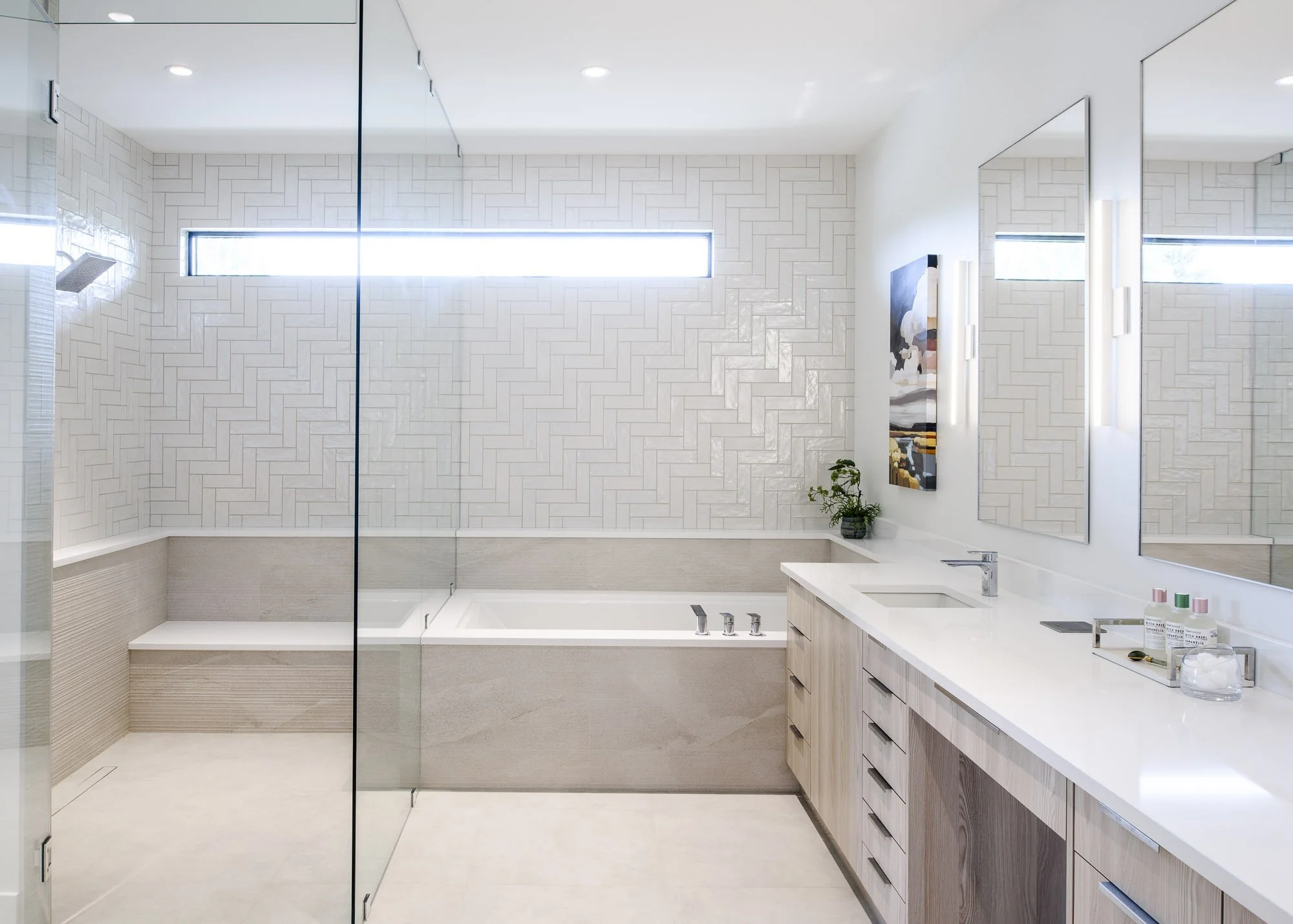 High-end master bathroom with walk-in glass shower, deep soaking tub, and custom cabinetry