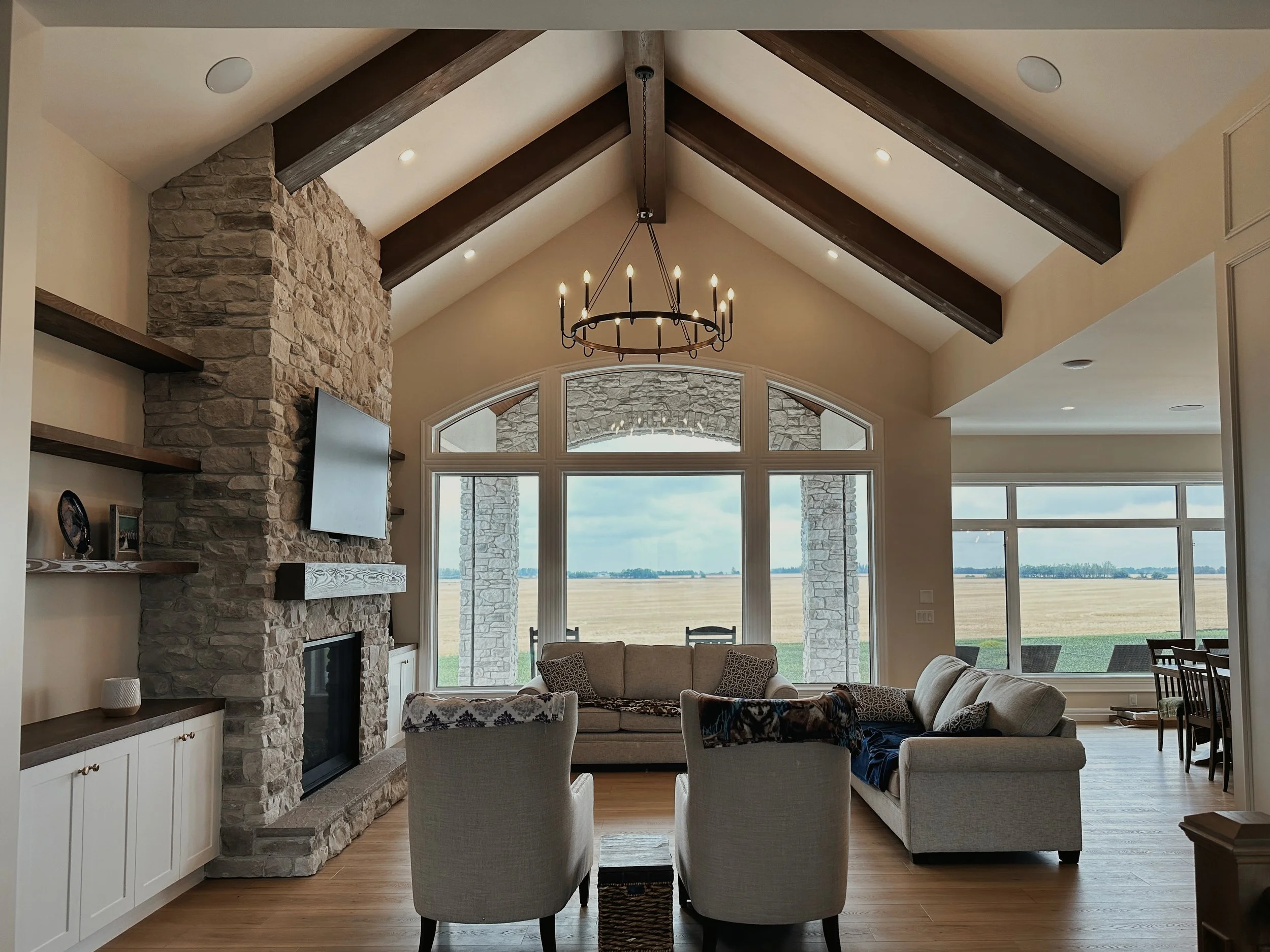 A Living Room with large windows, tall ceilings and exposed wood beams