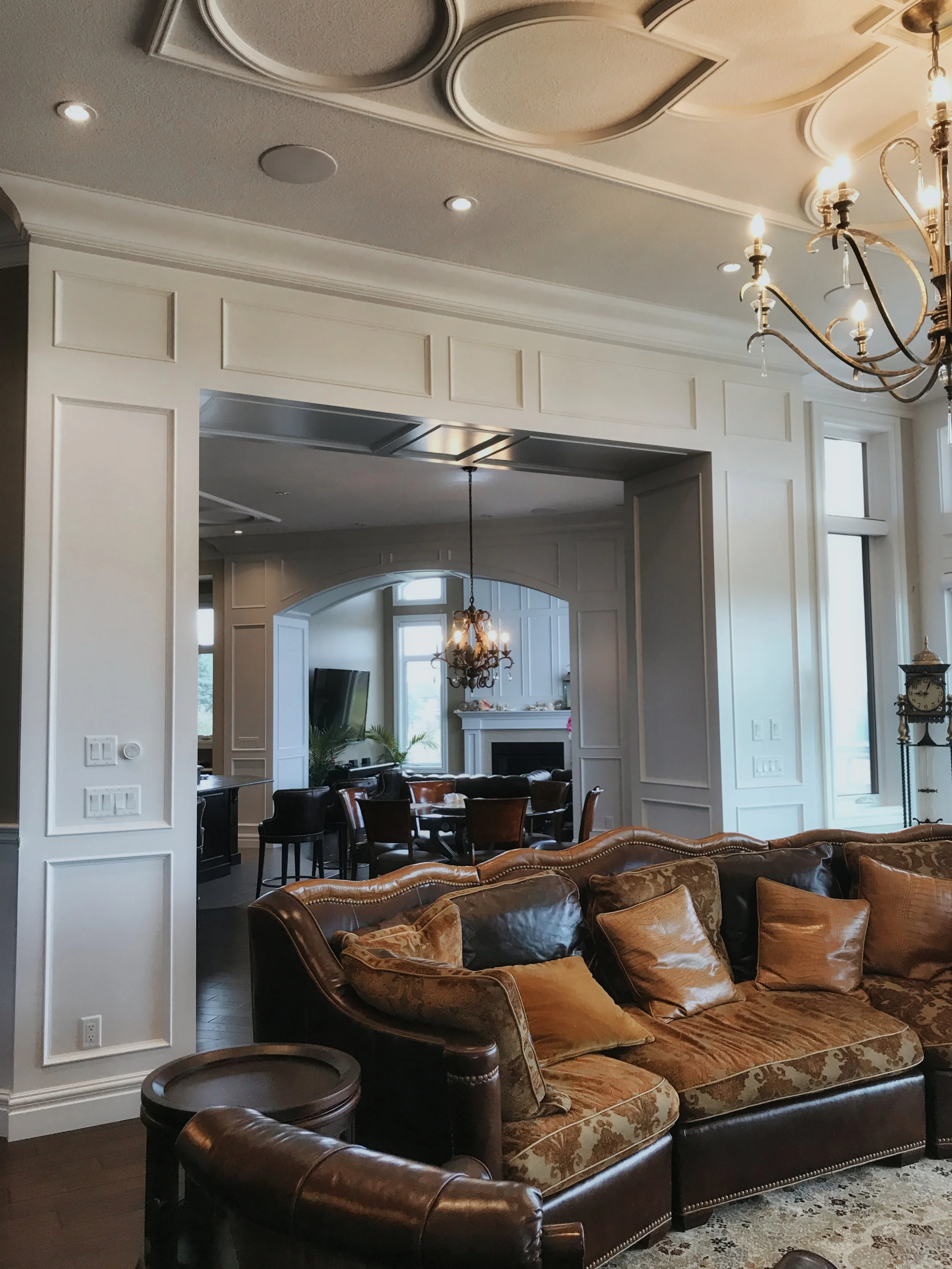 Refined home interior showcasing intricate ceiling design, white paneling, and transitional decor elements.