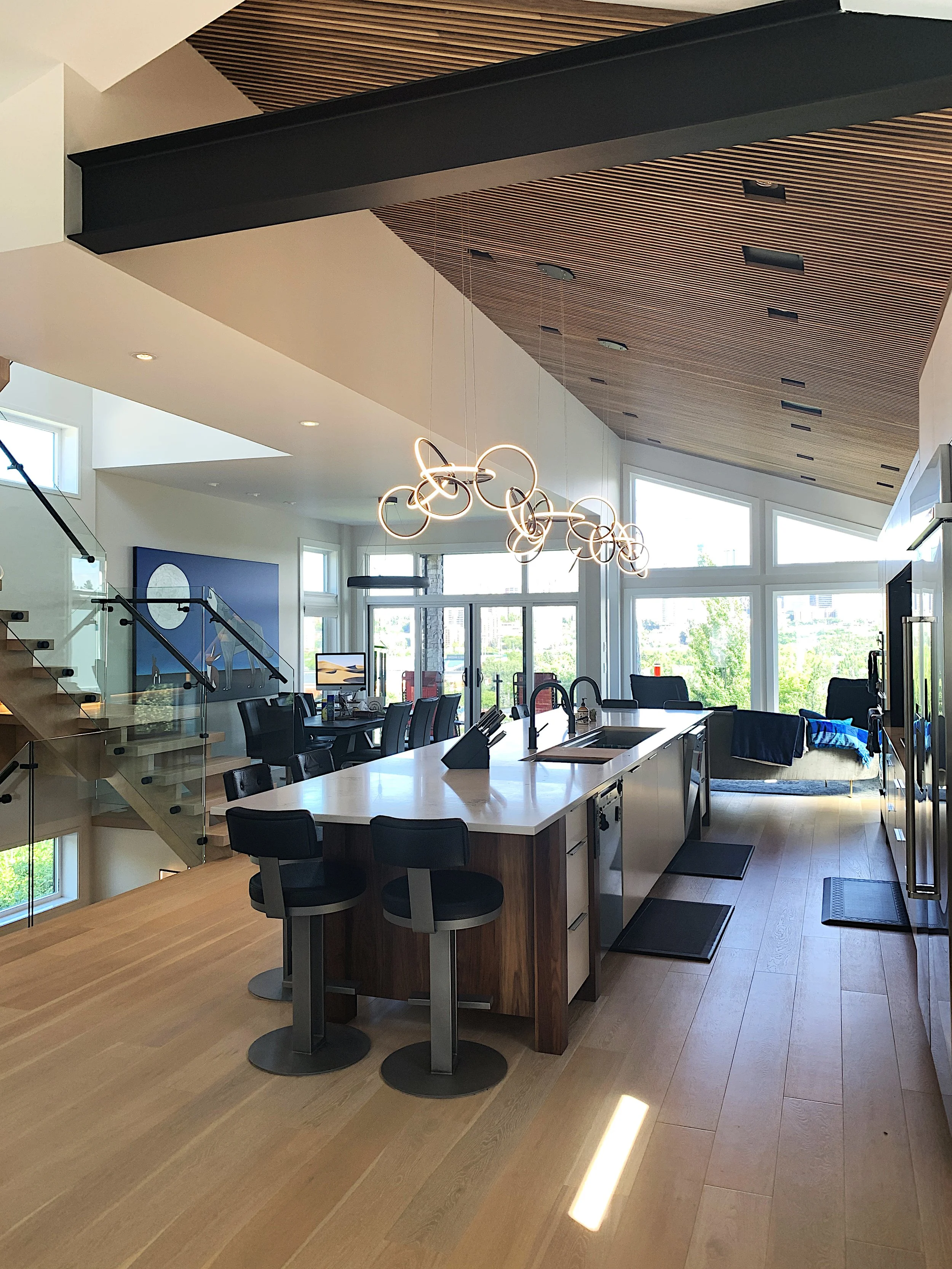 A kitchen with a large island and Walnut slat ceiling