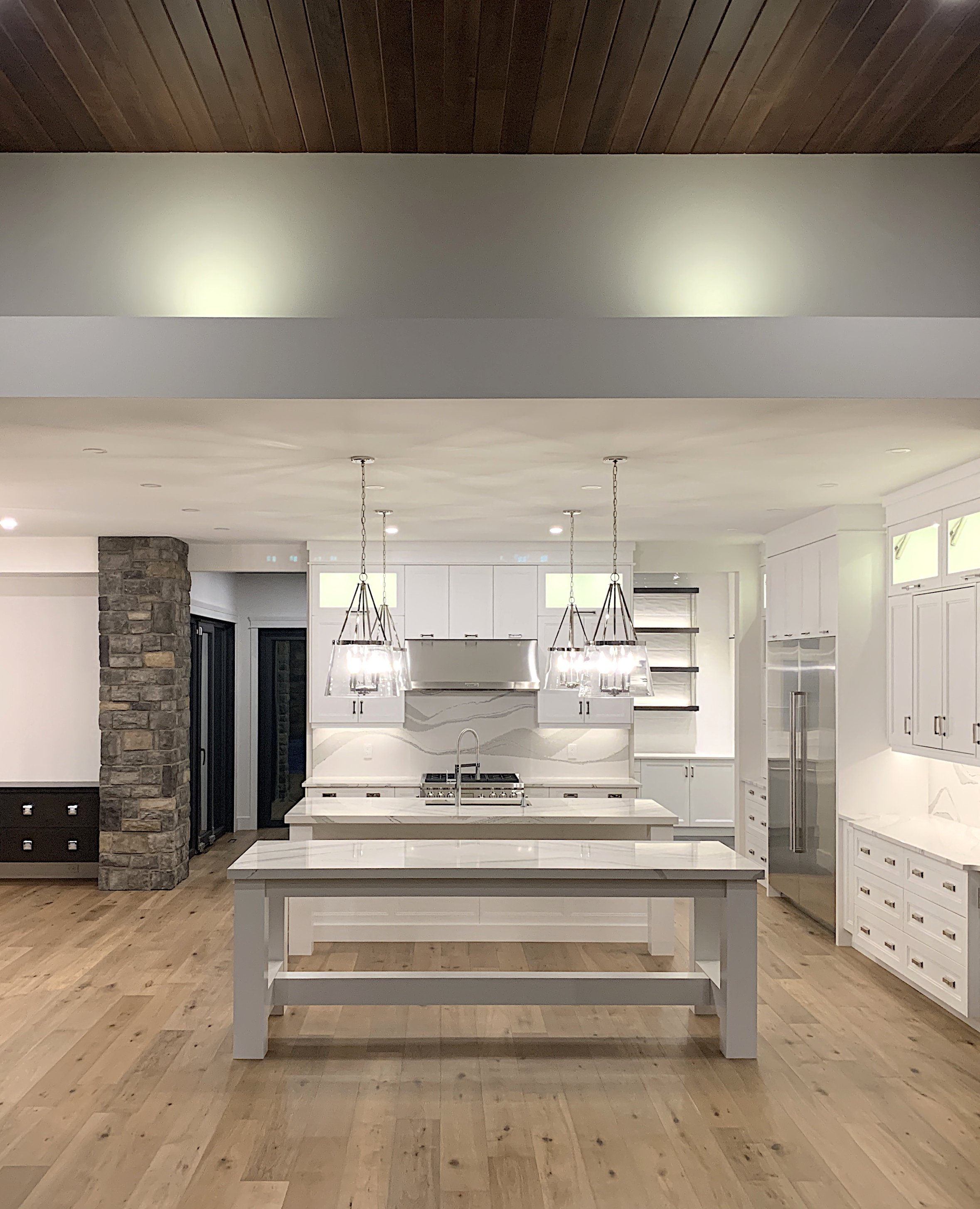 A large kitchen with white cabinets and custom island