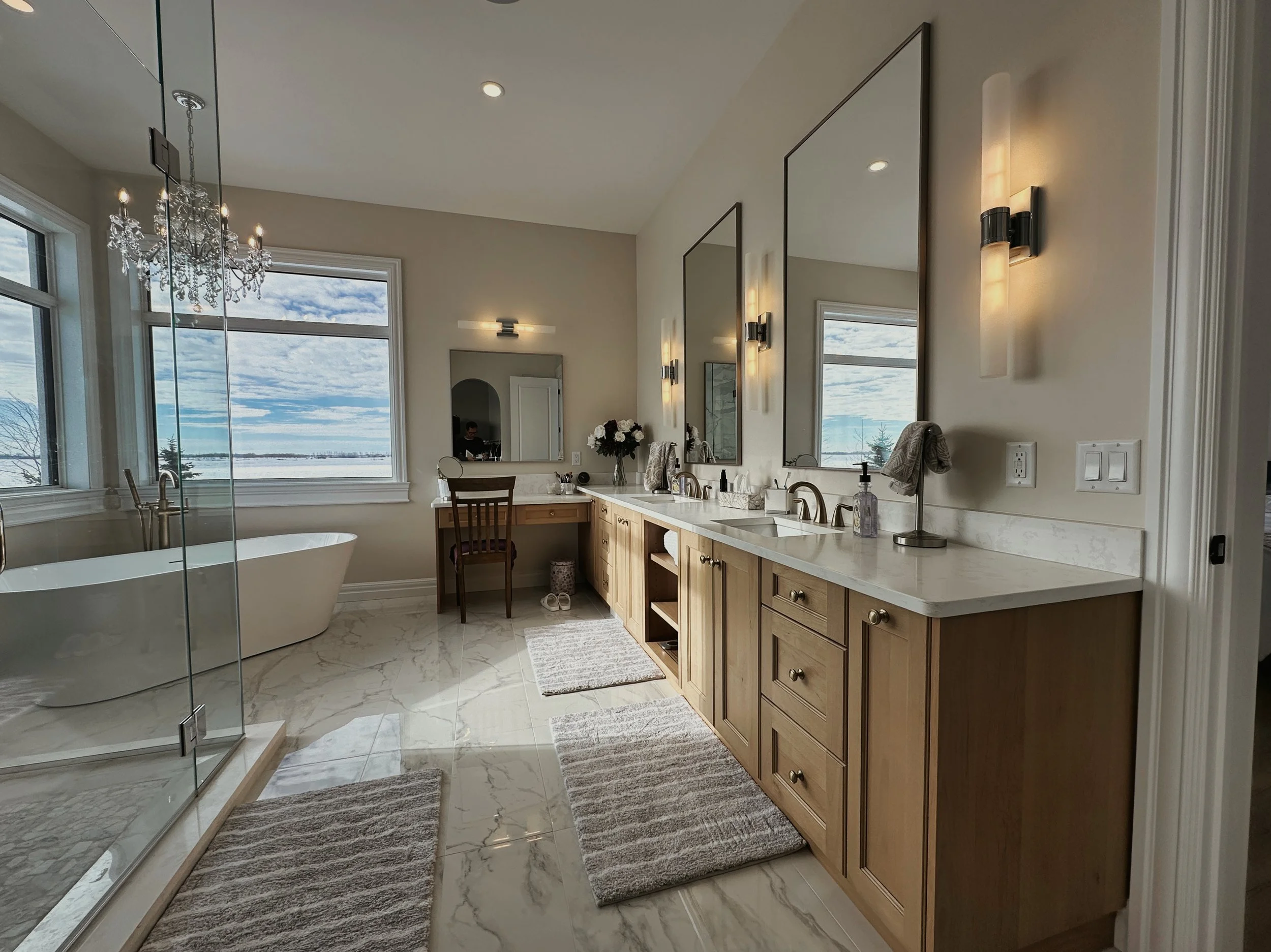An Ensuite Bathroom with doub;e sinks, brown cabinets and free standing tub