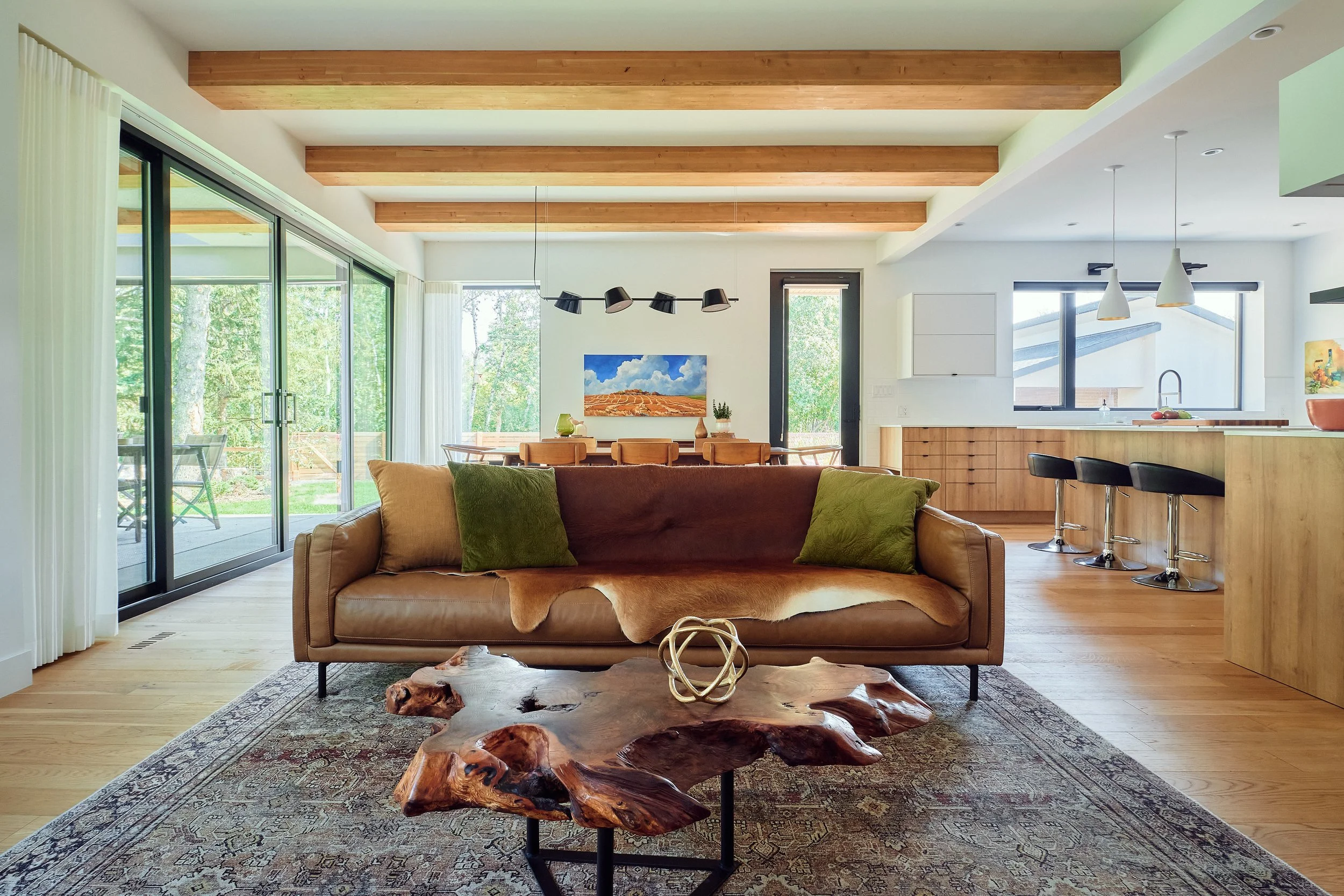 Stylish home interior with sliding glass doors, pendant lighting, and integrated living-dining-kitchen layout.