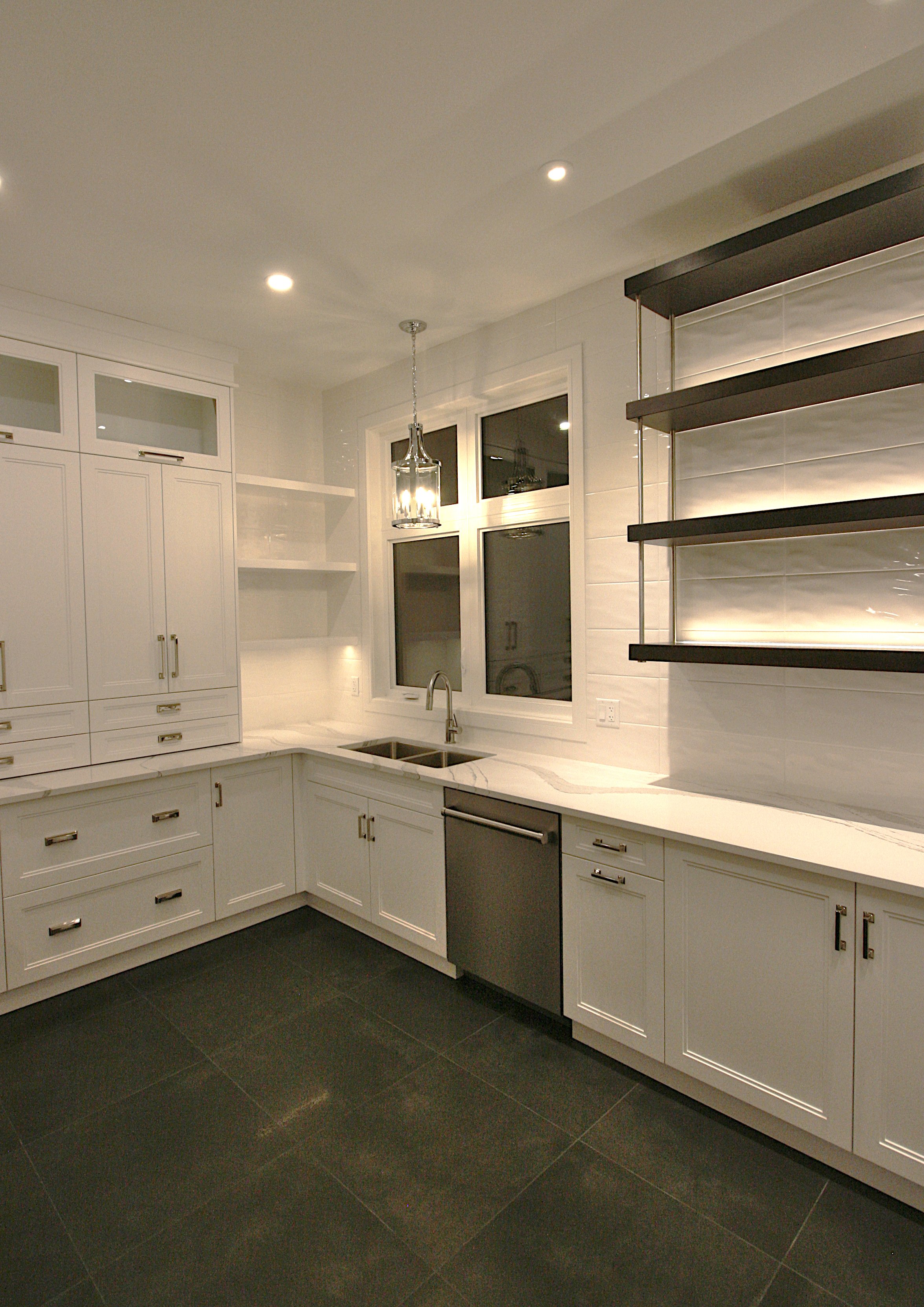 A butler pantry with white cabinets and floating shelves