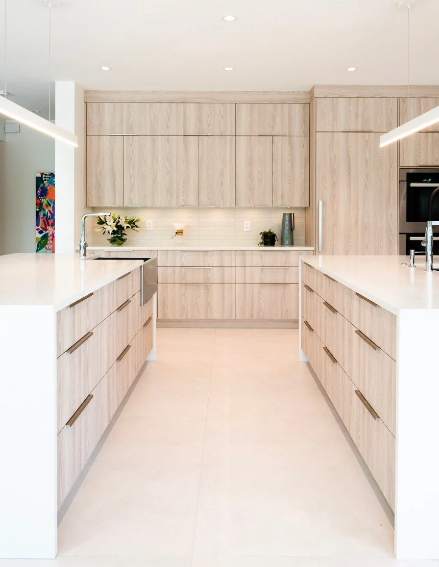 High-end kitchen design with custom wood cabinetry, integrated oven, and white waterfall countertops.