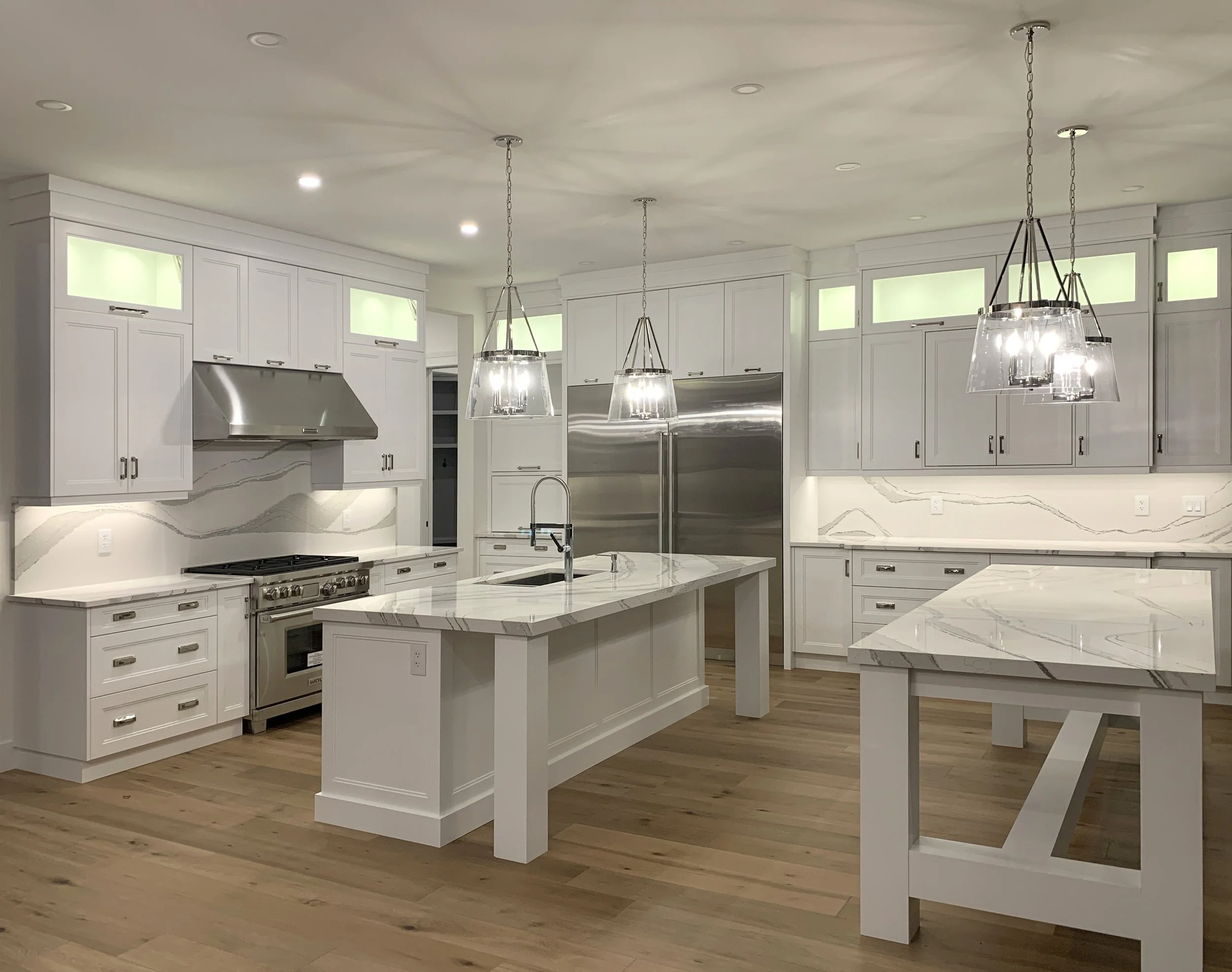 A kitchen with white cabinets and a large island