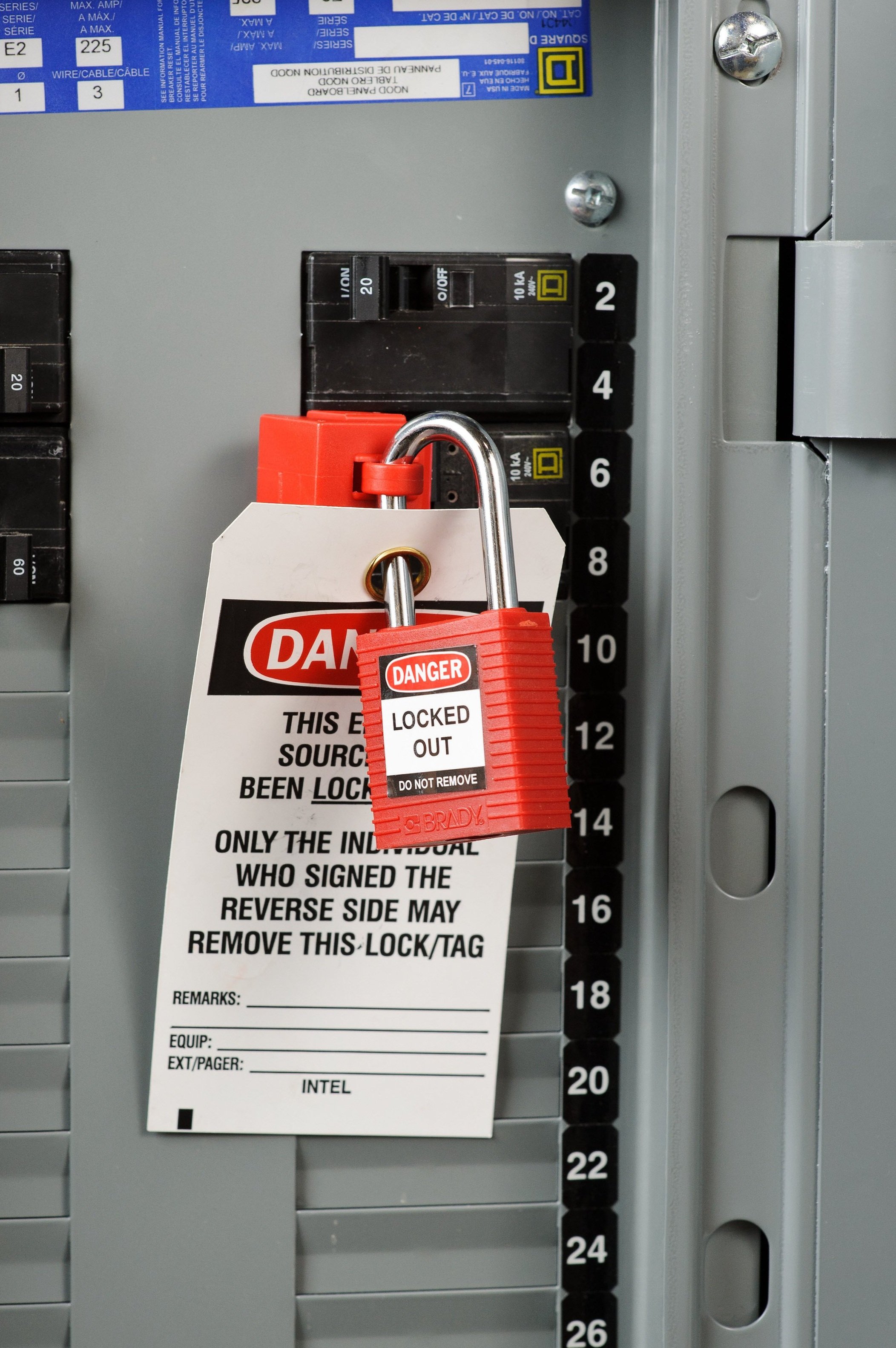 Electrical circuit breaker panel with a red lockout tag indicating the equipment is locked out and should not be operated.