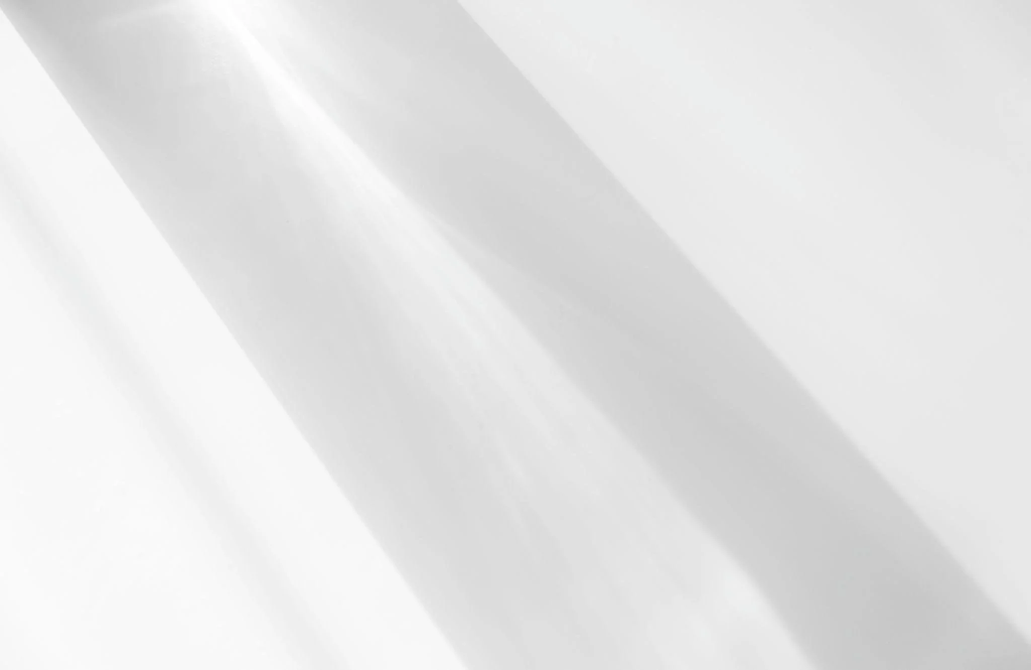 Abstract image with light and shadow creating diagonal lines in shades of white and gray.