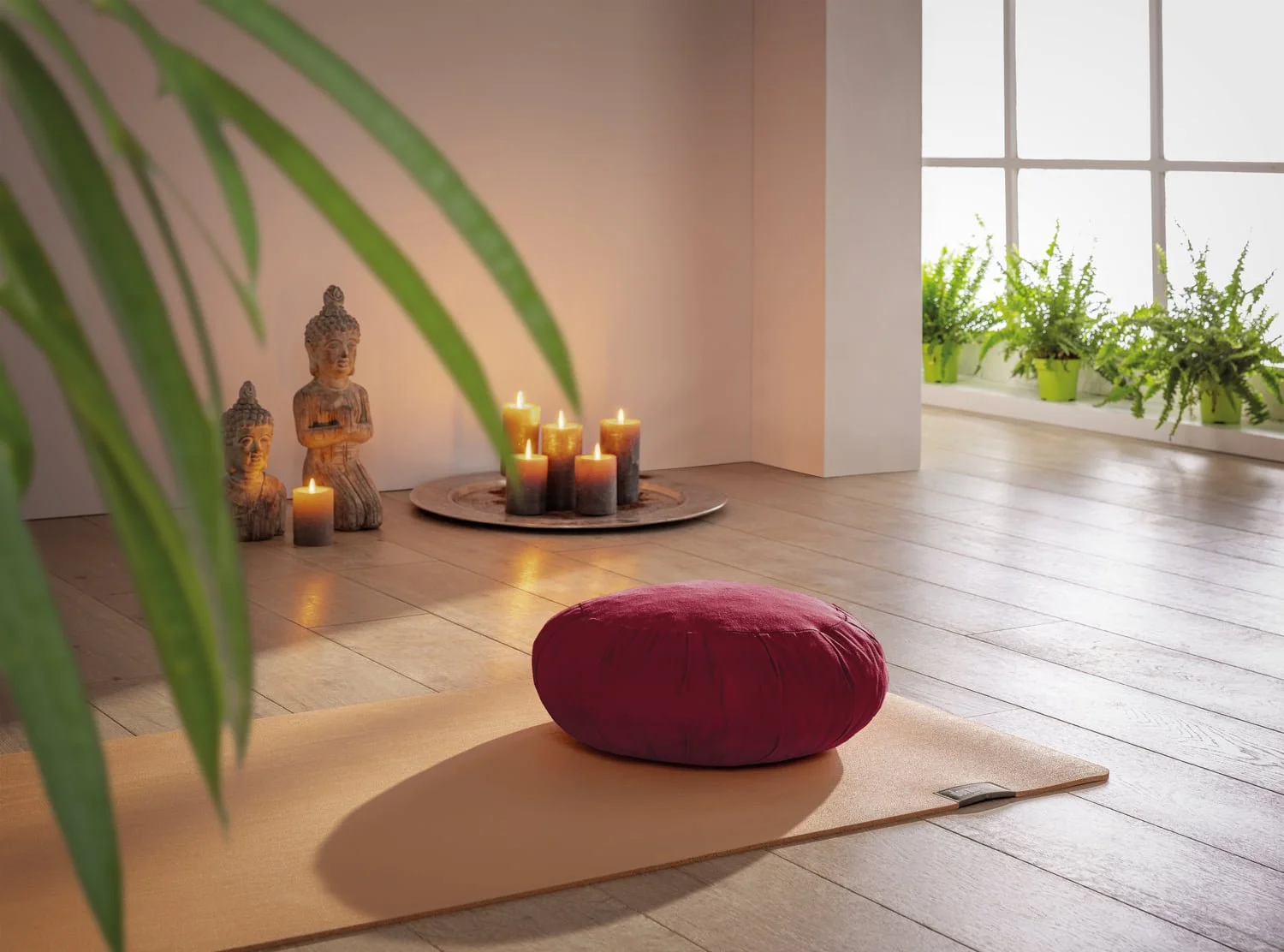 Plum meditation cushion on an apricot natural latex yoga mat in a bright room