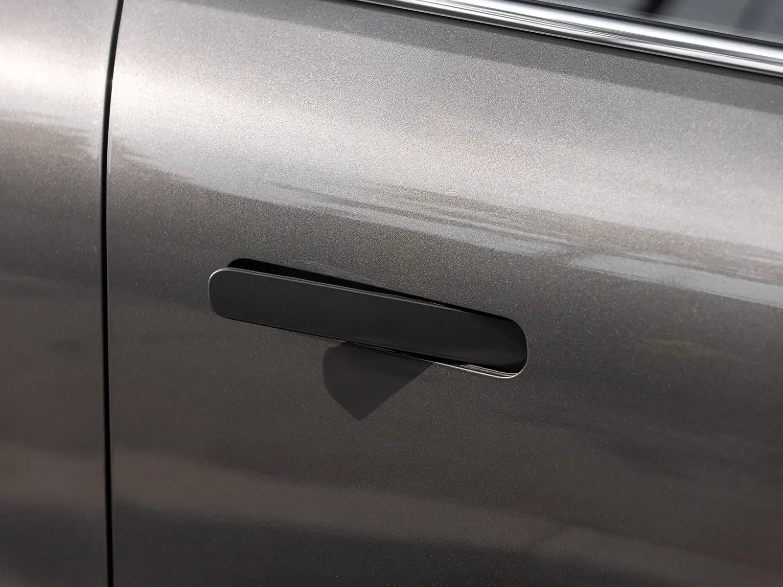 Puerta de coche gris con manija negra y línea de diseño en la carrocería.
