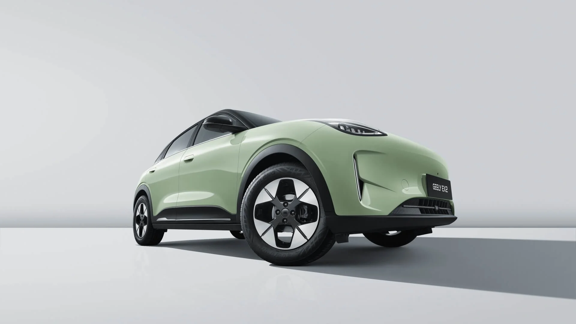 Coche eléctrico de color verde claro, estilo compacto, en un fondo gris claro, visto desde una vista frontal y lateral en un entorno minimalista.