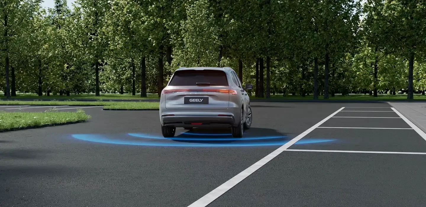 Automóvil gris estacionado en un espacio de parqueo, con un sistema de asistencia de manejo activado