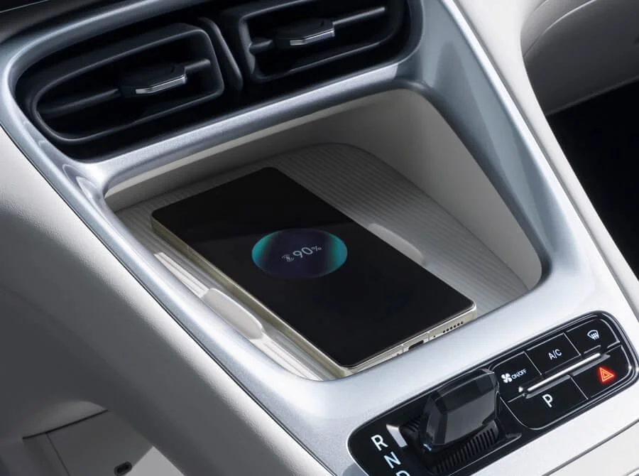 Teléfono móvil cargándose en la consola del coche con pantalla que indica 90% de batería.