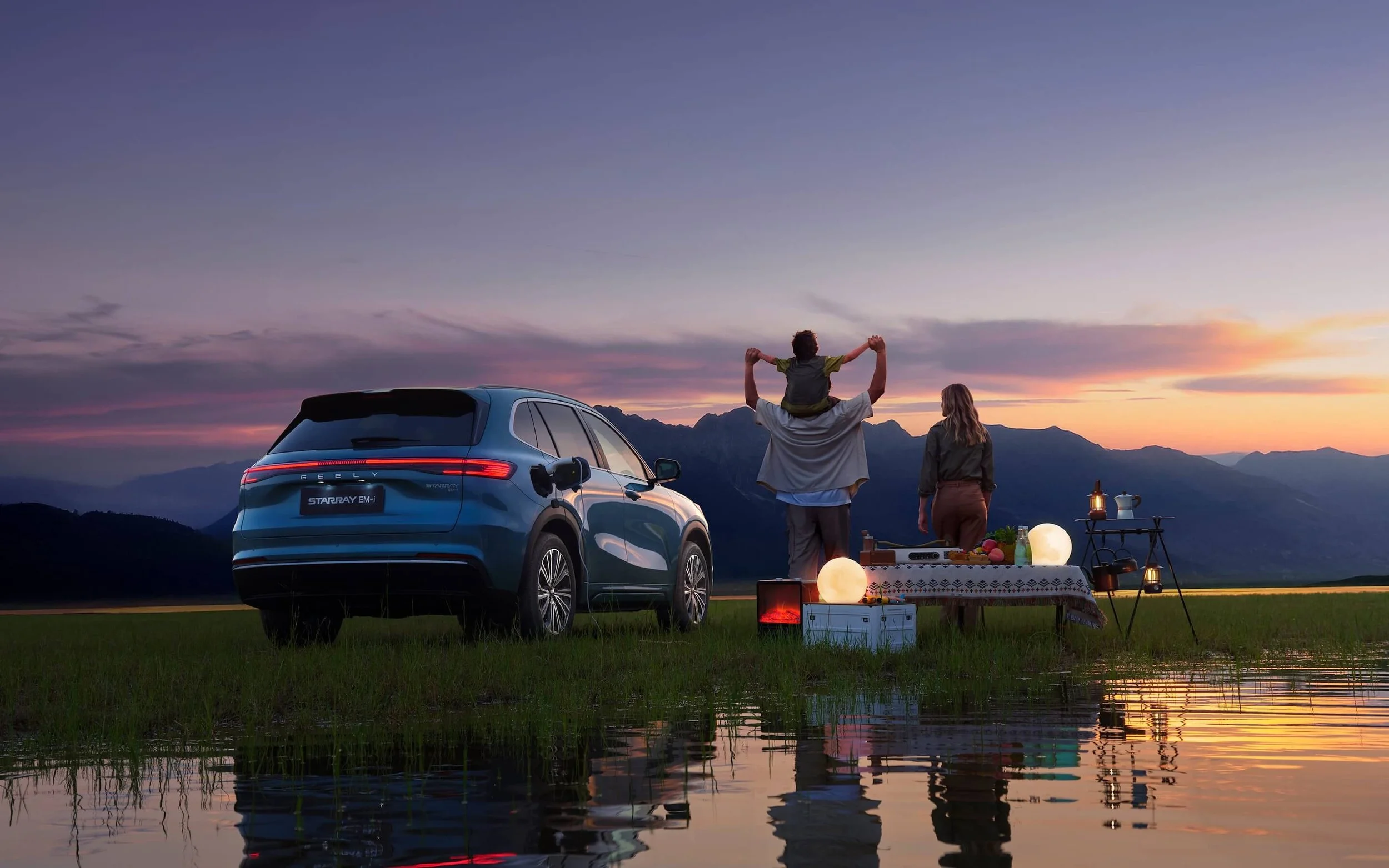 Pareja en picnic con coche azul en un paisaje montañoso al atardecer, con iluminación decorativa y una mesa con comida y lámparas.