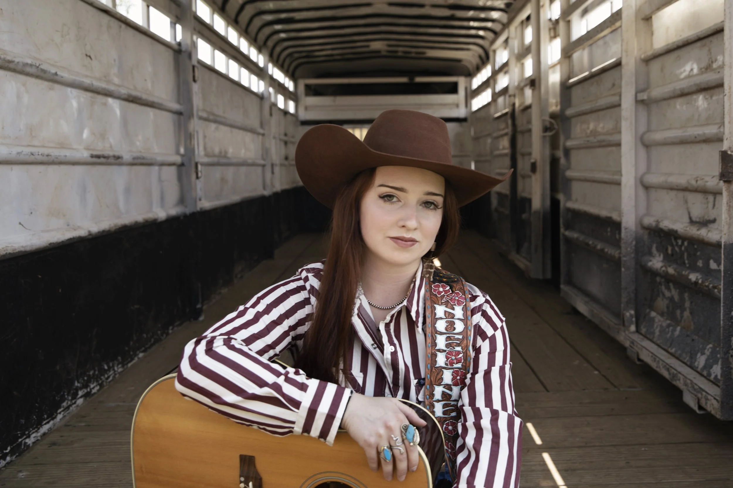 Breakout Country music artist Noeline Hofmann in a photograph in the back of a horse trailer from a video shoot with Western AF.