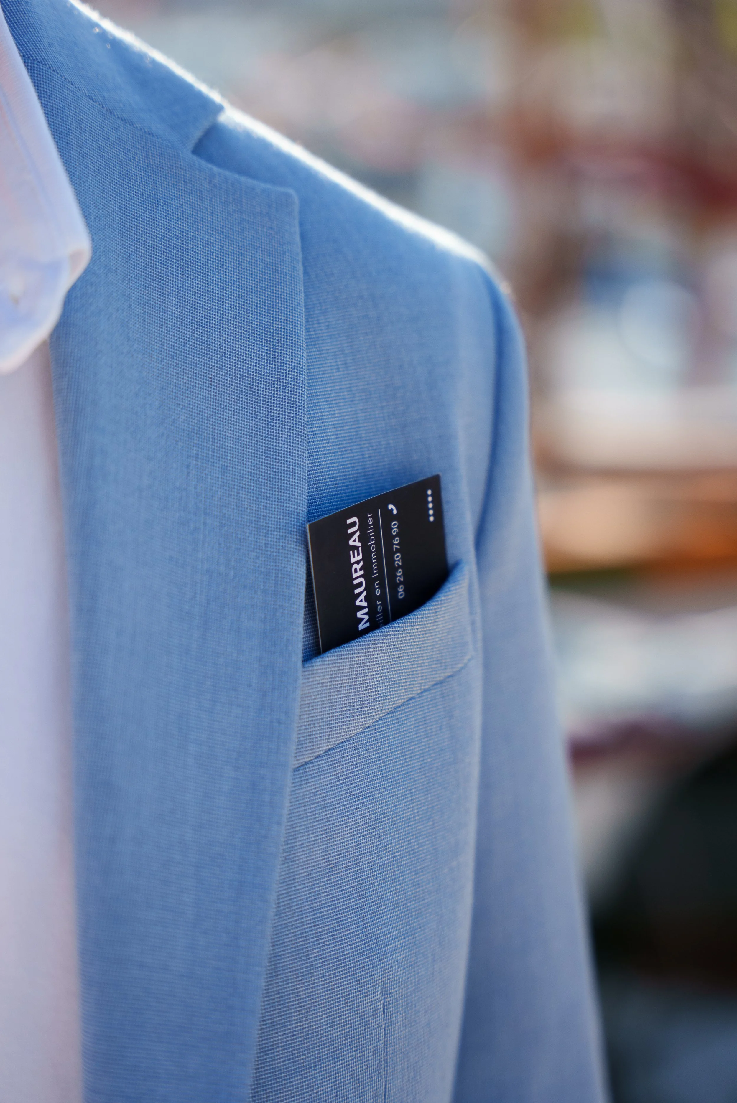 Une veste bleue avec une carte de visite dans la poche poitrine.