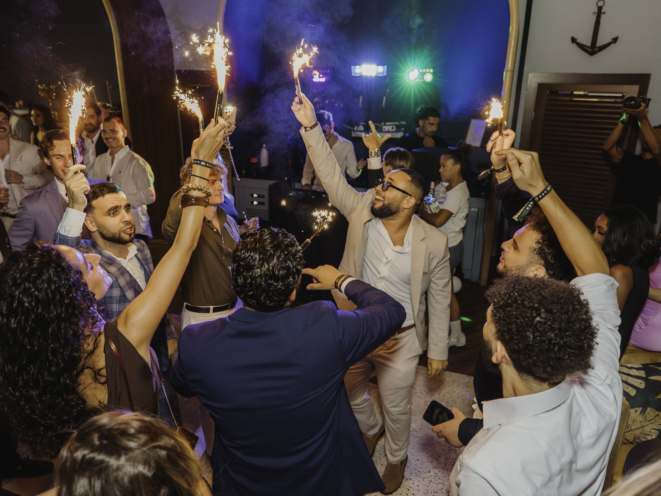 Groupe de personnes danseurs célébrant avec des feux d'artifice ou des flambeaux lors d'une fête ou d'une célébration dans une ambiance festive.