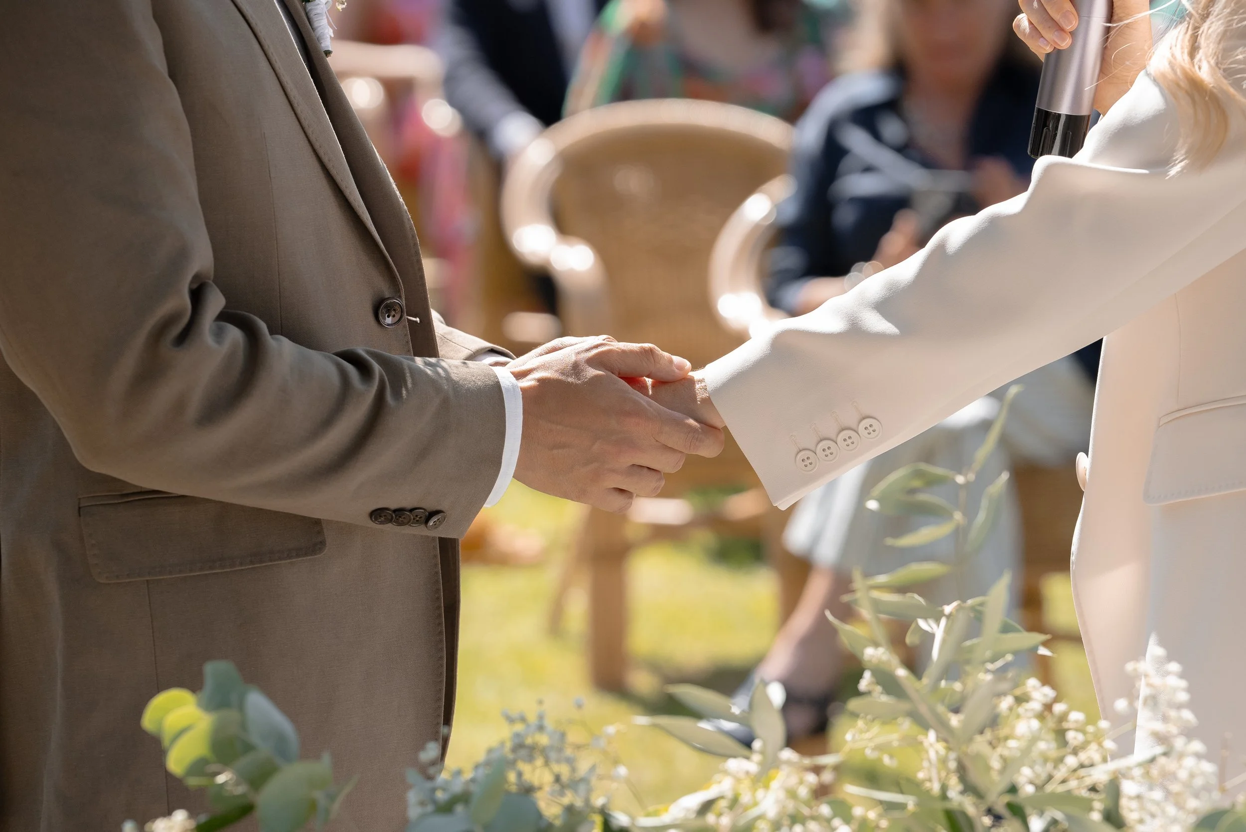 Deux personnes se serrent la main lors d'une cérémonie en plein air.