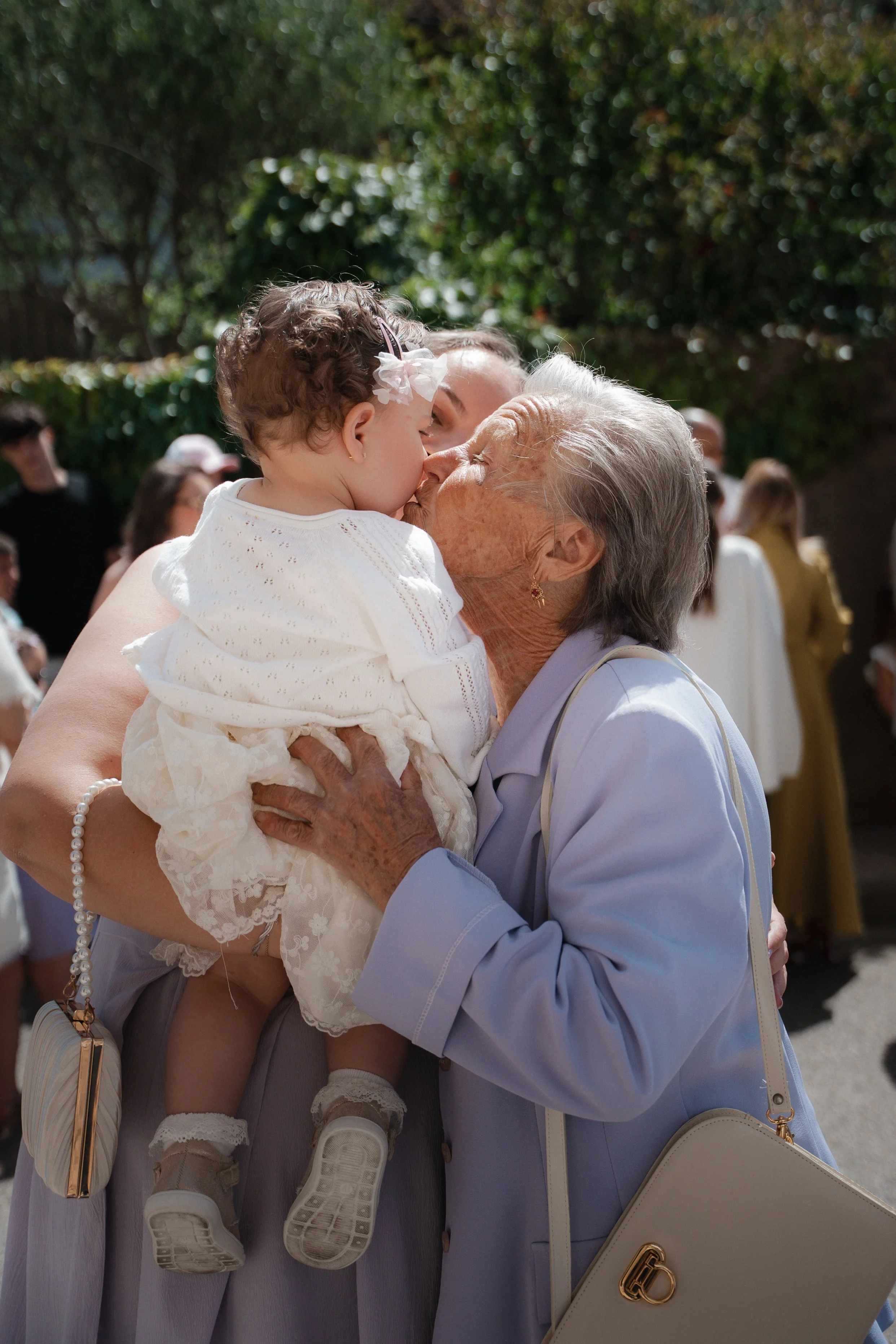 Une grand-mère embrasse tendrement une petite fille lors d'un rassemblement en plein air.