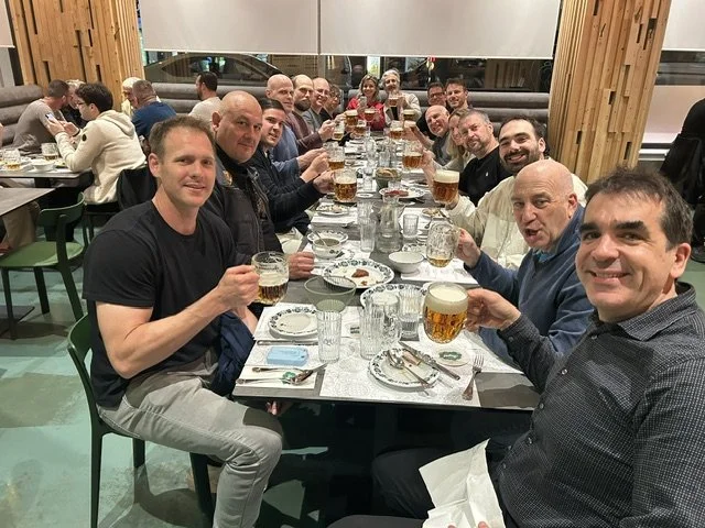 Teams raising a toast at dinner in a Prague pub