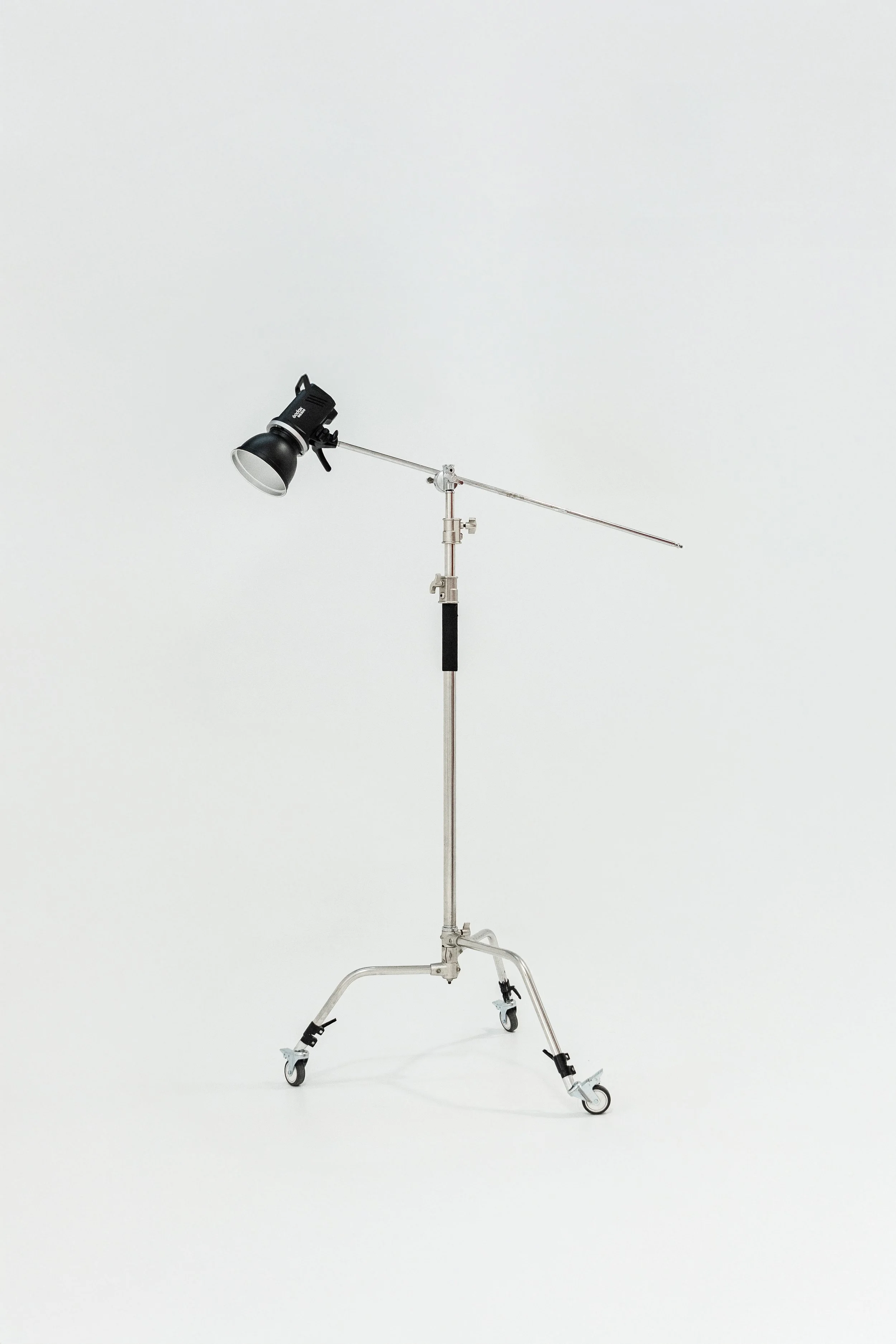 Turntable lighting equipment with stand and wheel on a white background.
