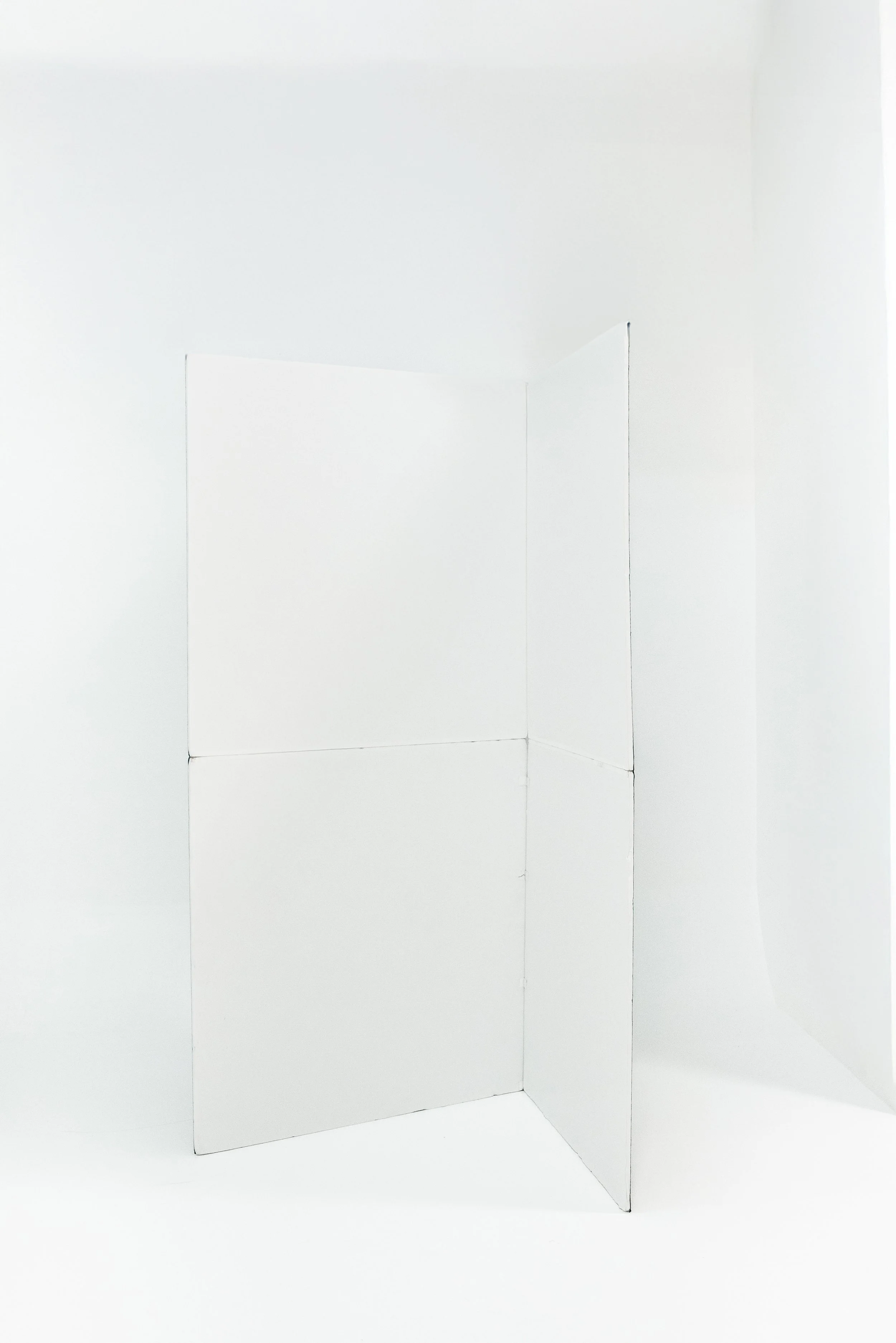 White cardboard wall with a corner, set against a white background.
