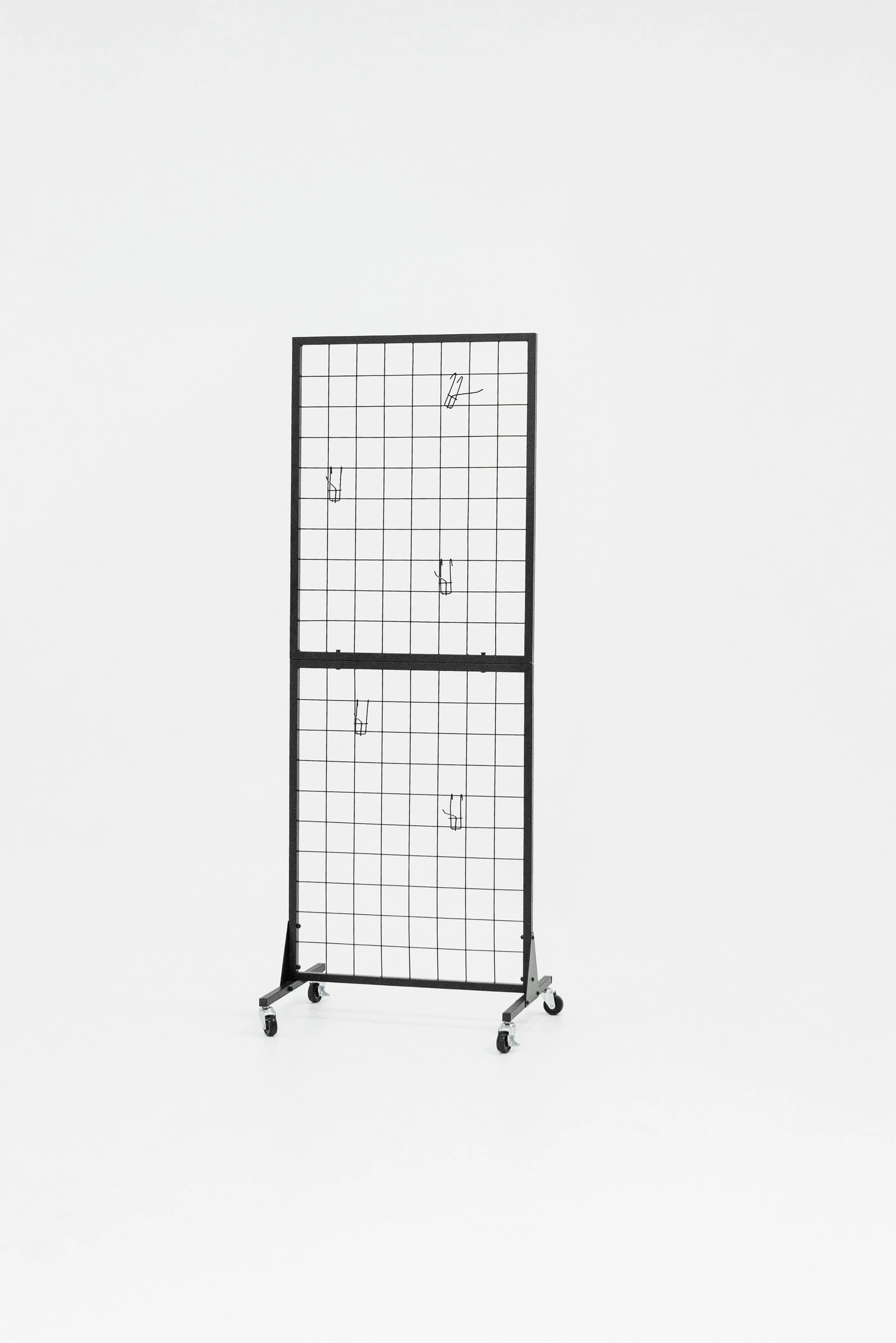 A black freestanding grid display with two sections, each on wheels, against a plain white background.